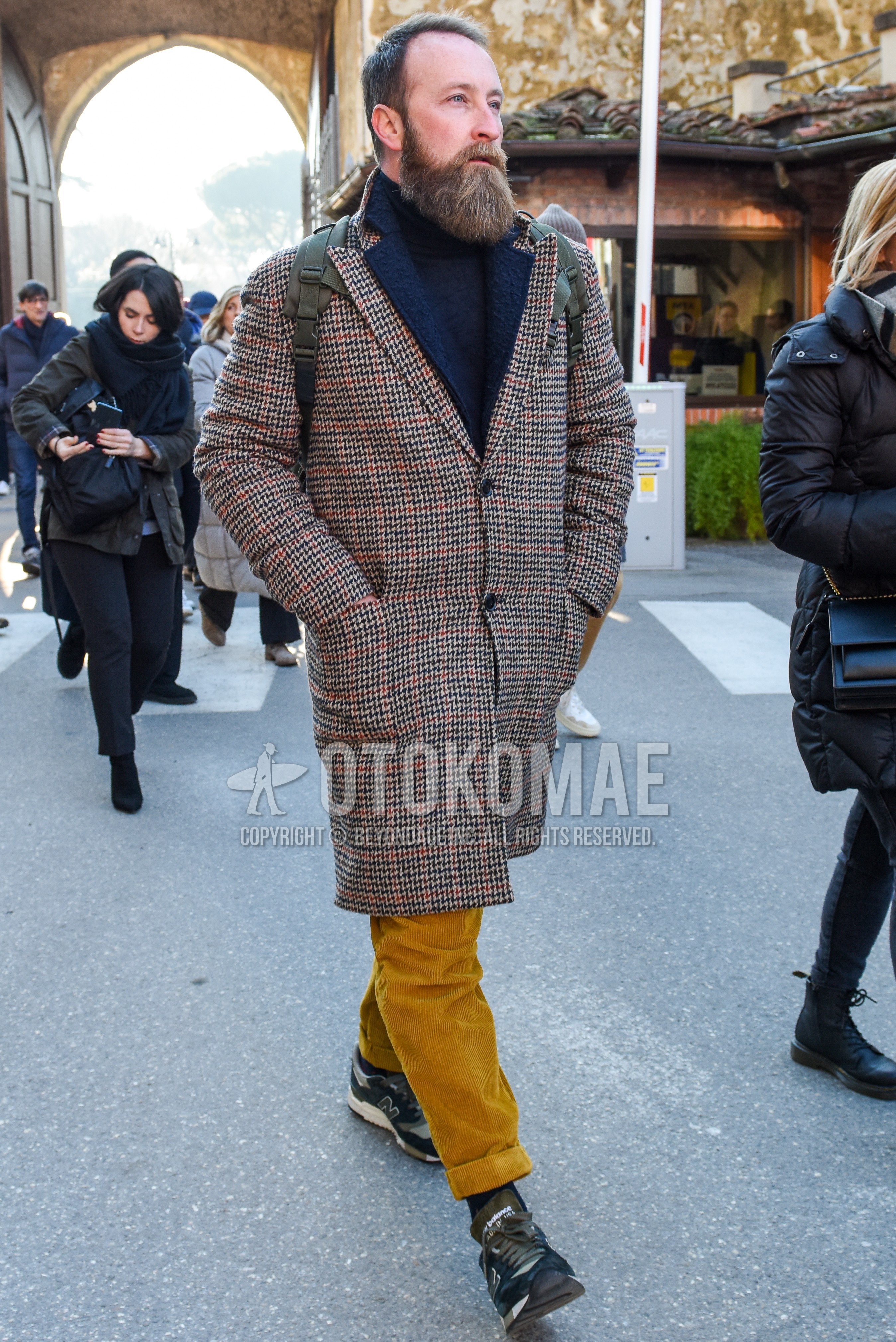 Men's autumn winter outfit with multi-color outerwear chester coat, dark gray plain turtleneck knit, beige plain winter pants (corduroy,velour), navy plain socks, navy low-cut sneakers.