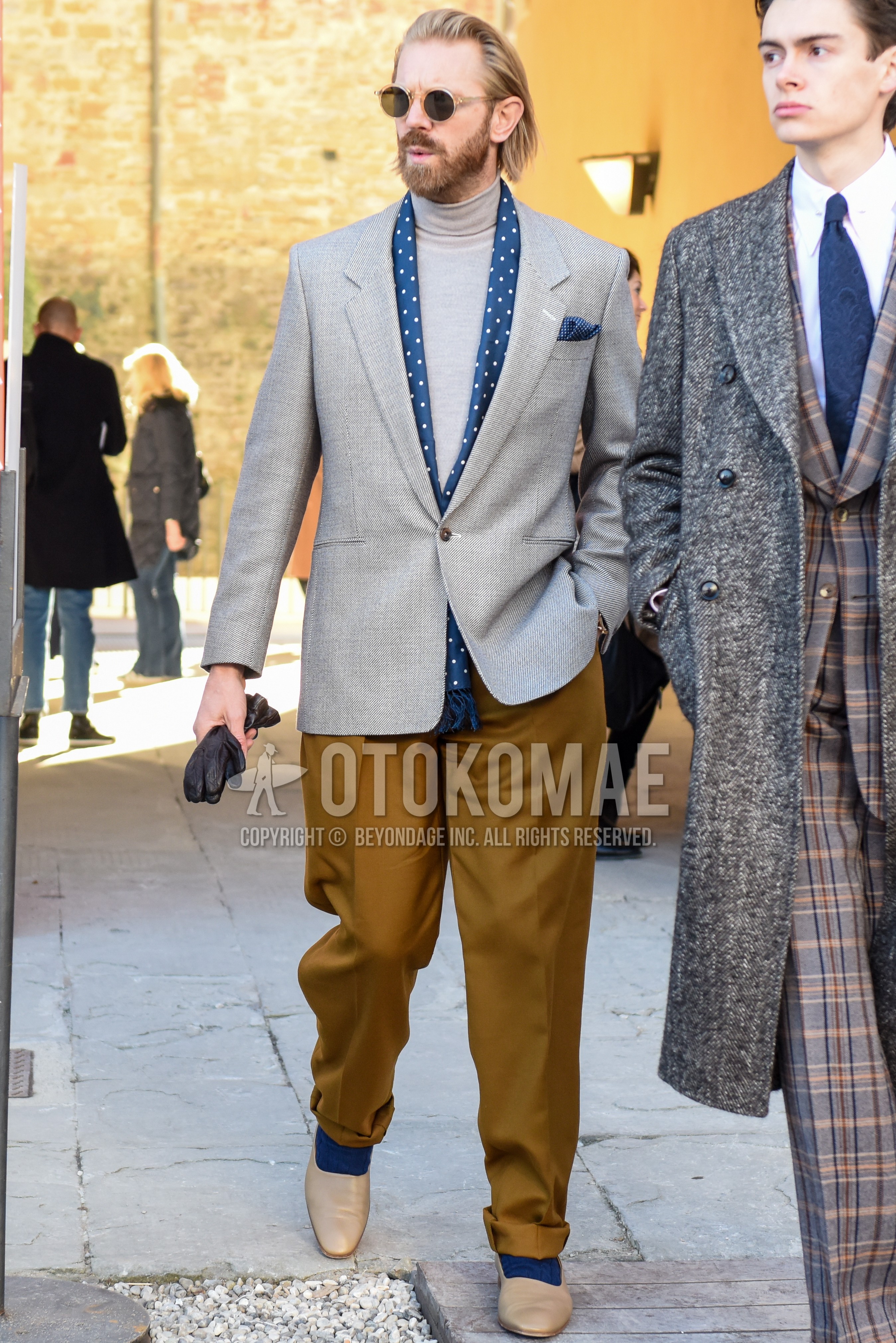 Men's spring autumn outfit with clear plain sunglasses, navy dots scarf, gray plain tailored jacket, gray plain turtleneck knit, beige plain chinos, beige plain pleated pants, navy plain socks, beige  loafers leather shoes.