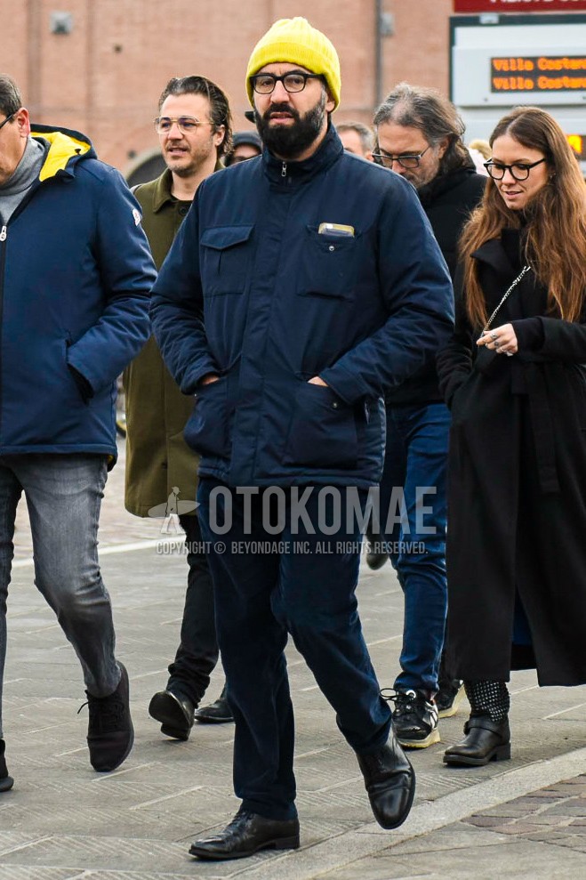 Men's winter outfit with yellow plain knit cap, plain glasses, navy plain M-65, navy plain winter pants (corduroy,velour), black straight-tip shoes leather shoes.