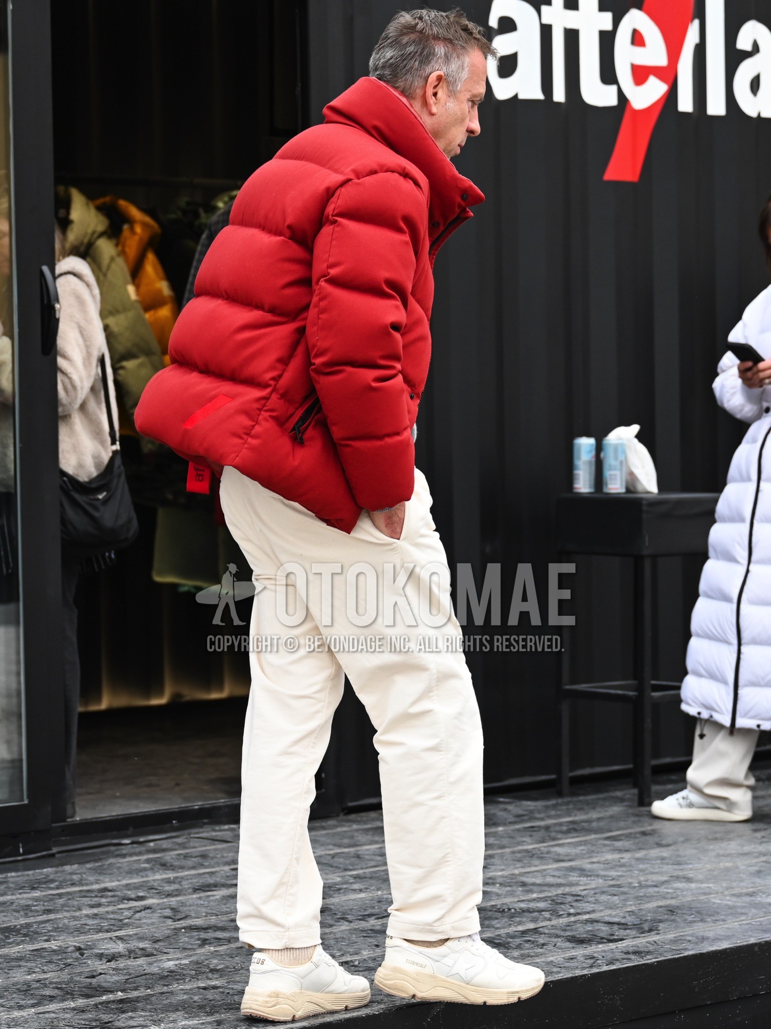 Men's autumn winter outfit with red plain down jacket, white plain cotton pants, beige plain socks, white low-cut sneakers.