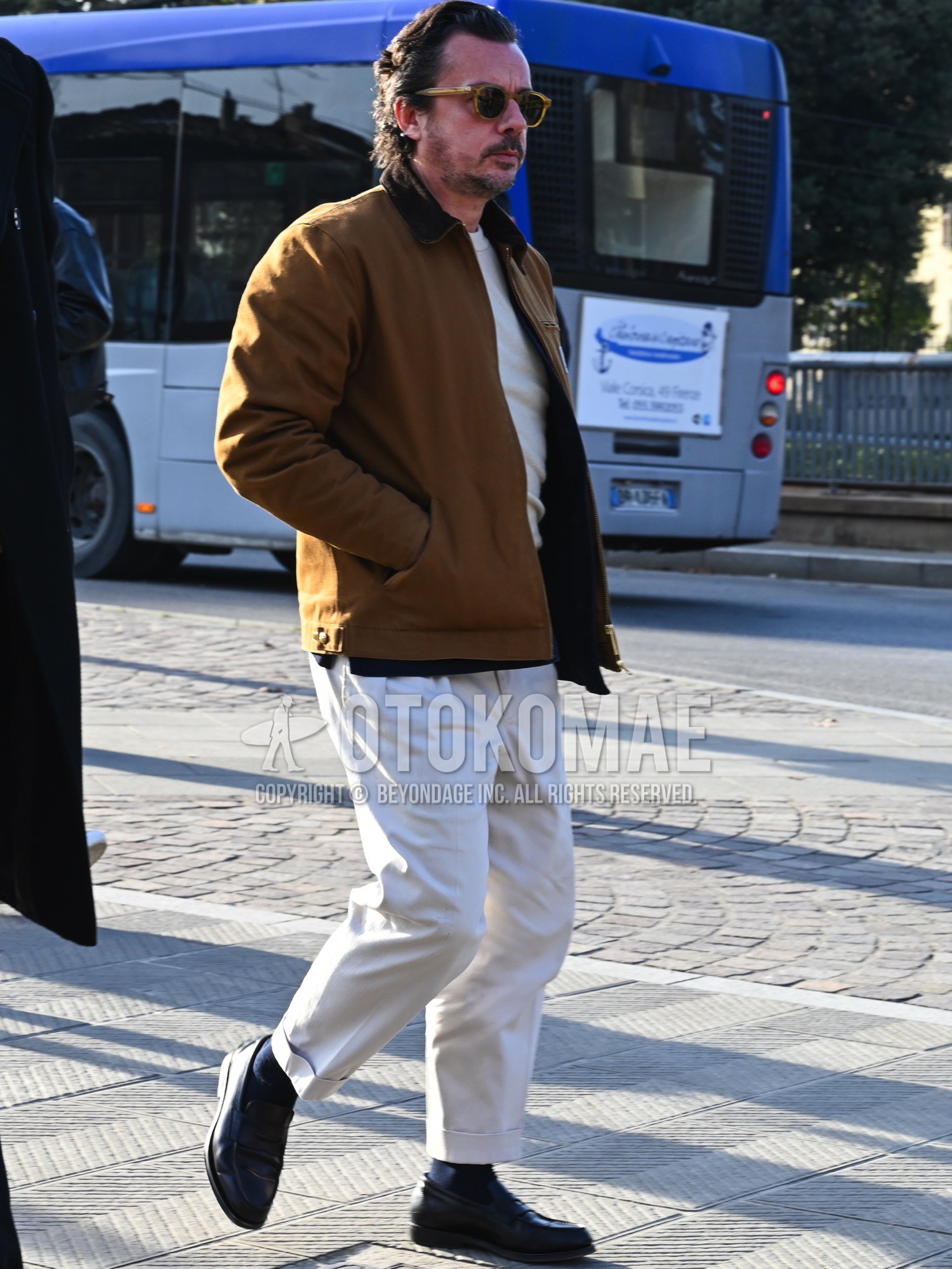 Men's autumn winter outfit with brown plain sunglasses, brown plain coverall, white plain sweater, white plain slacks, navy plain socks, black coin loafers leather shoes.