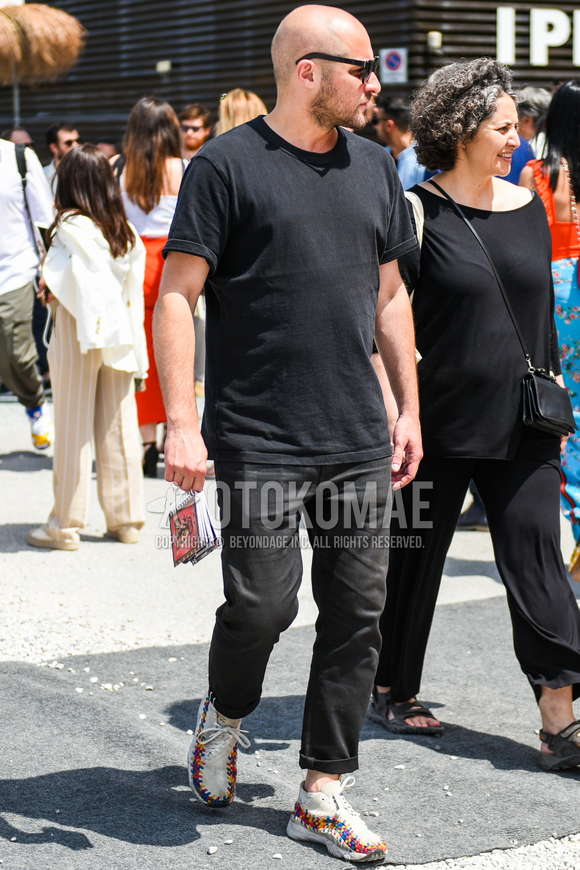 Men's summer outfit with black plain sunglasses, black plain t-shirt, dark gray plain denim/jeans, white high-cut sneakers.