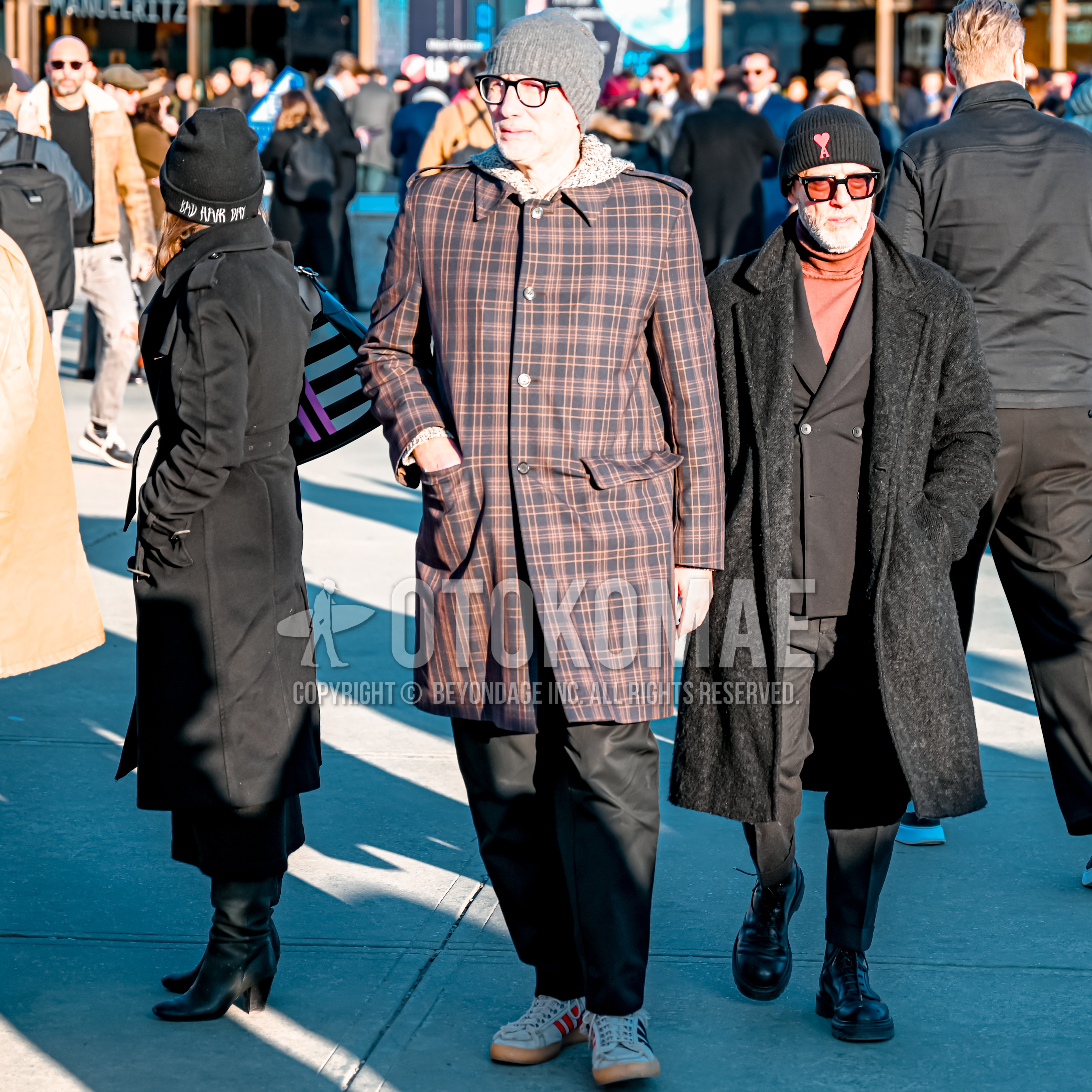 Men's autumn winter outfit with gray plain knit cap, black plain glasses, brown black check stenkarrer coat, gray tops/innerwear hoodie, black plain wide pants, white low-cut sneakers.