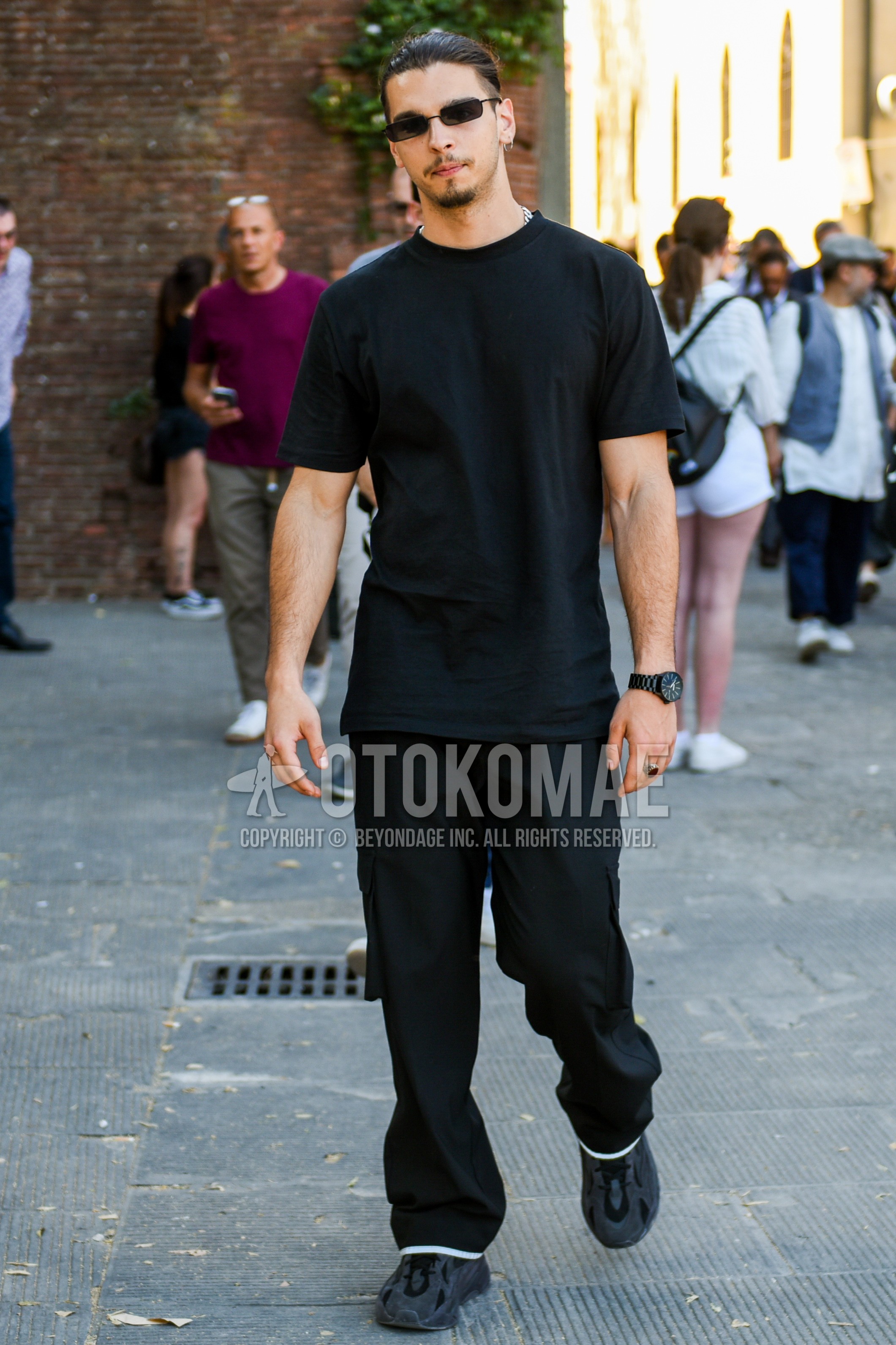 Men's summer outfit with black plain sunglasses, black plain t-shirt, black plain wide pants, black low-cut sneakers.