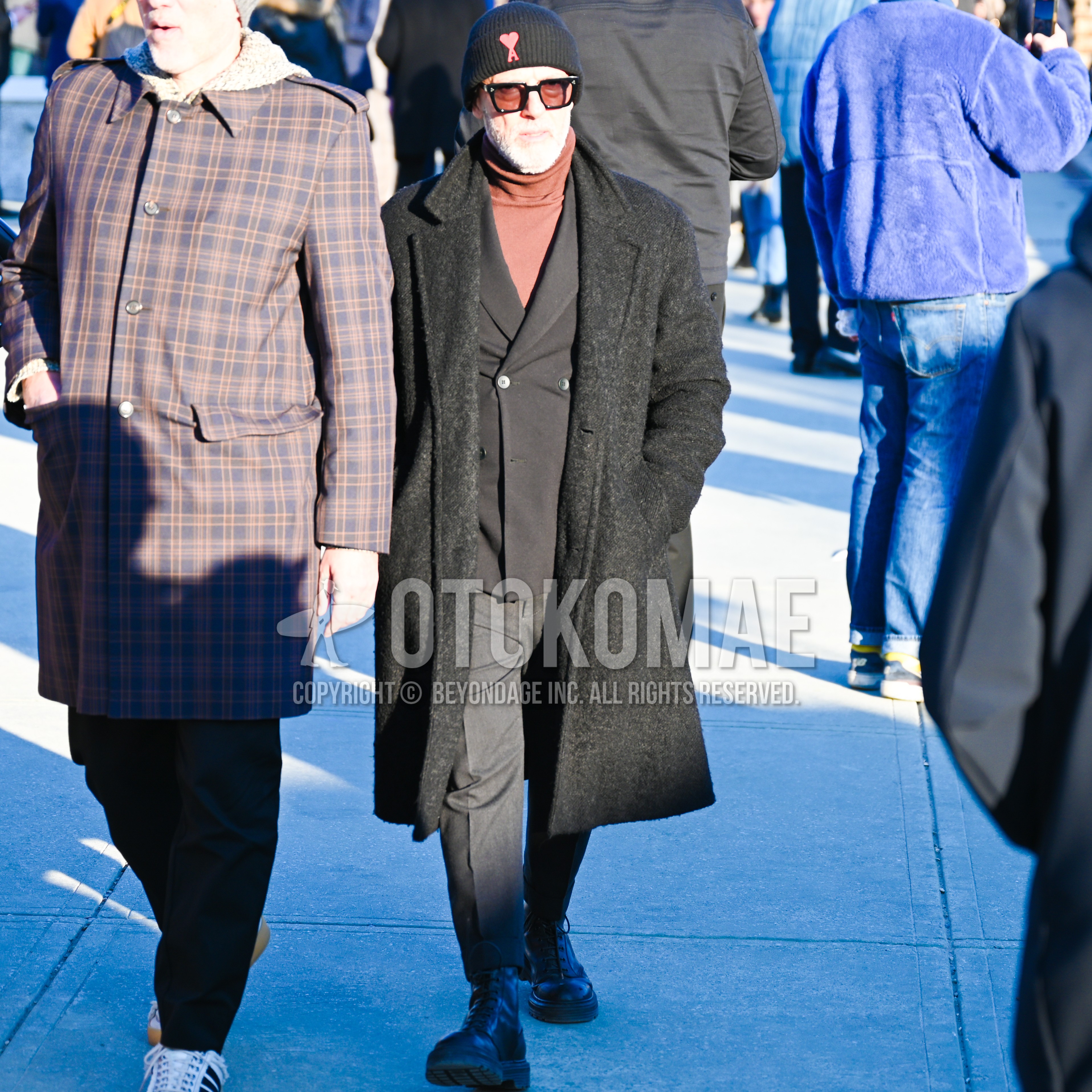 Men's autumn winter outfit with black one point knit cap, black plain sunglasses, black plain chester coat, brown plain turtleneck knit, black plain tailored jacket, dark gray plain slacks, black work boots.