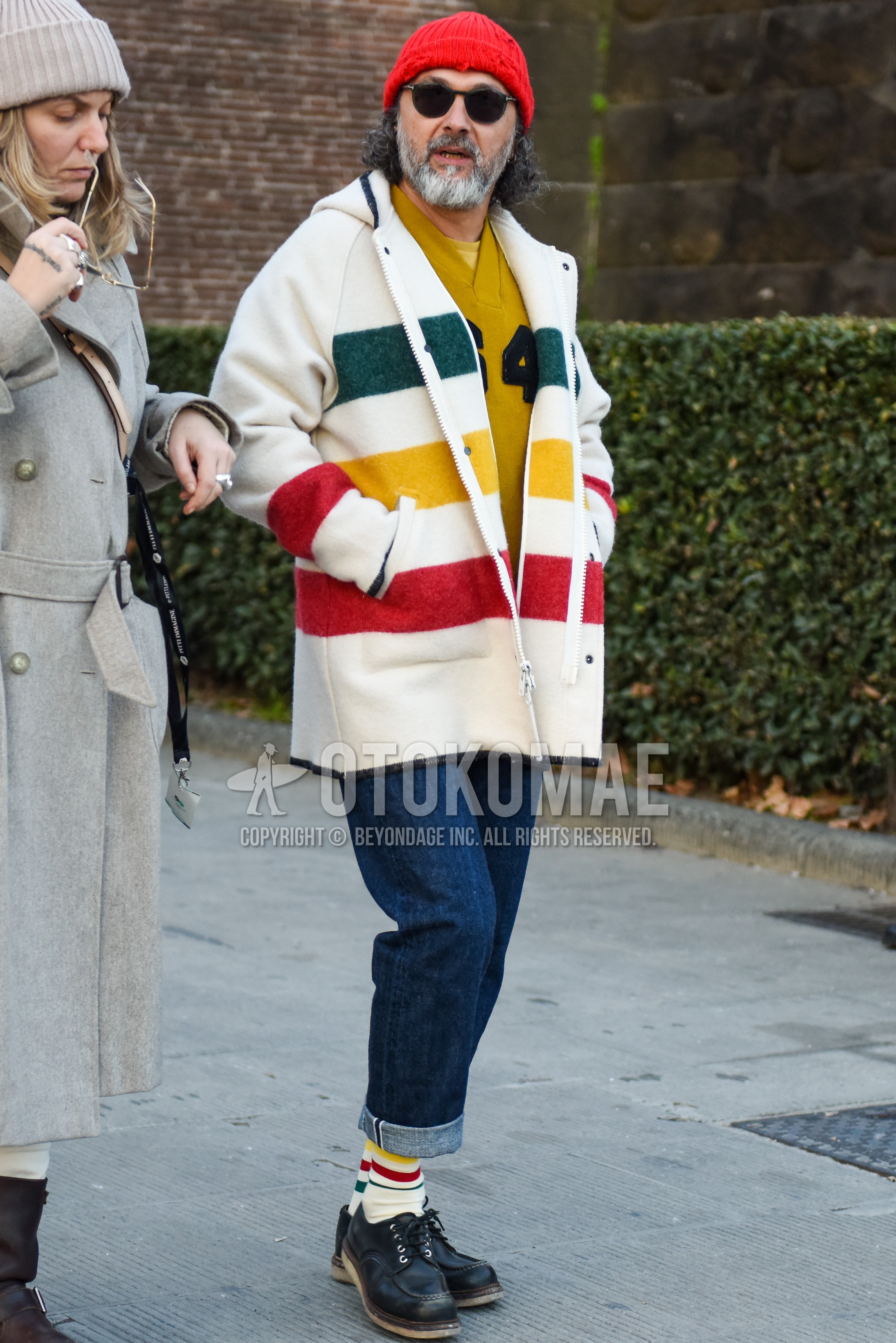 Men's autumn winter outfit with red plain knit cap, black plain sunglasses, white horizontal stripes hooded coat, yellow lettered sweatshirt, navy plain denim/jeans, white horizontal stripes socks, black u-tip shoes leather shoes.