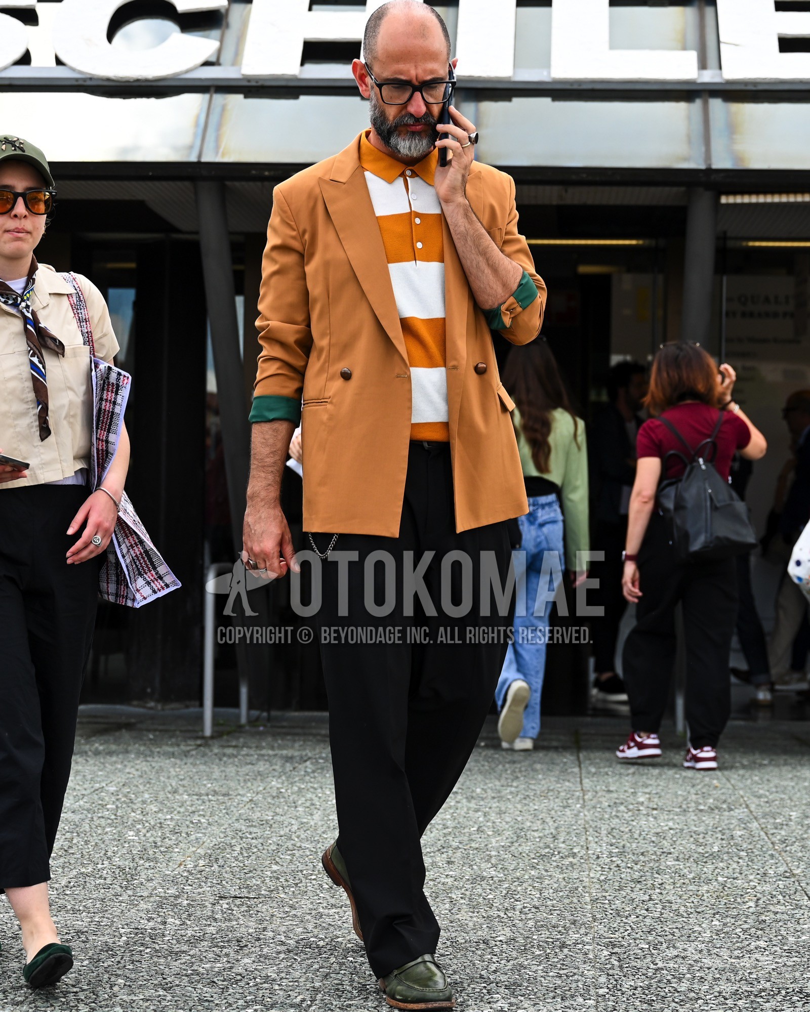 Men's spring summer autumn outfit with clear plain sunglasses, brown plain tailored jacket, white brown horizontal stripes polo shirt, black plain slacks, green coin loafers leather shoes.