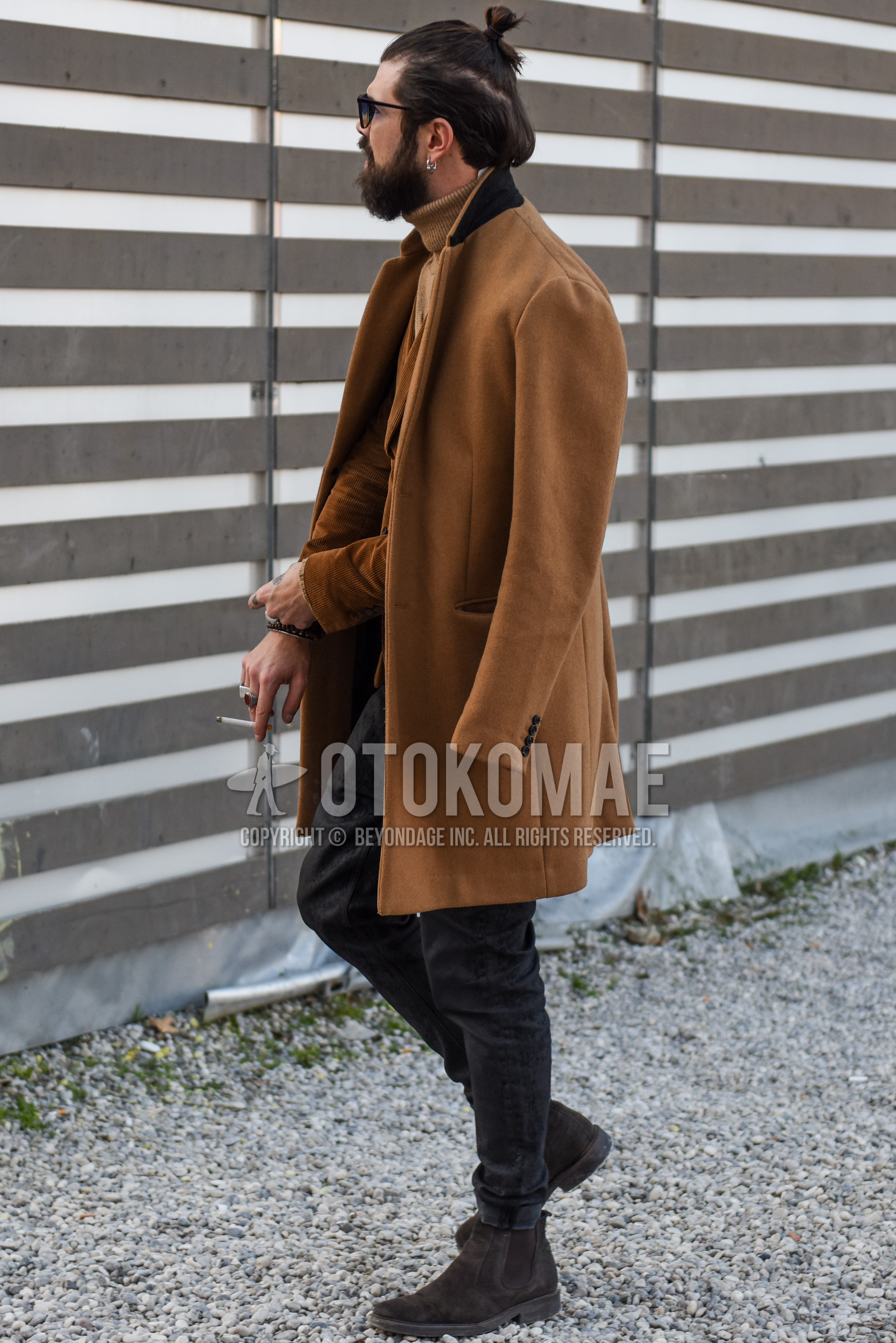Men's autumn winter outfit with black plain sunglasses, beige plain chester coat, beige plain tailored jacket, beige plain turtleneck knit, dark gray plain denim/jeans, brown side-gore boots.
