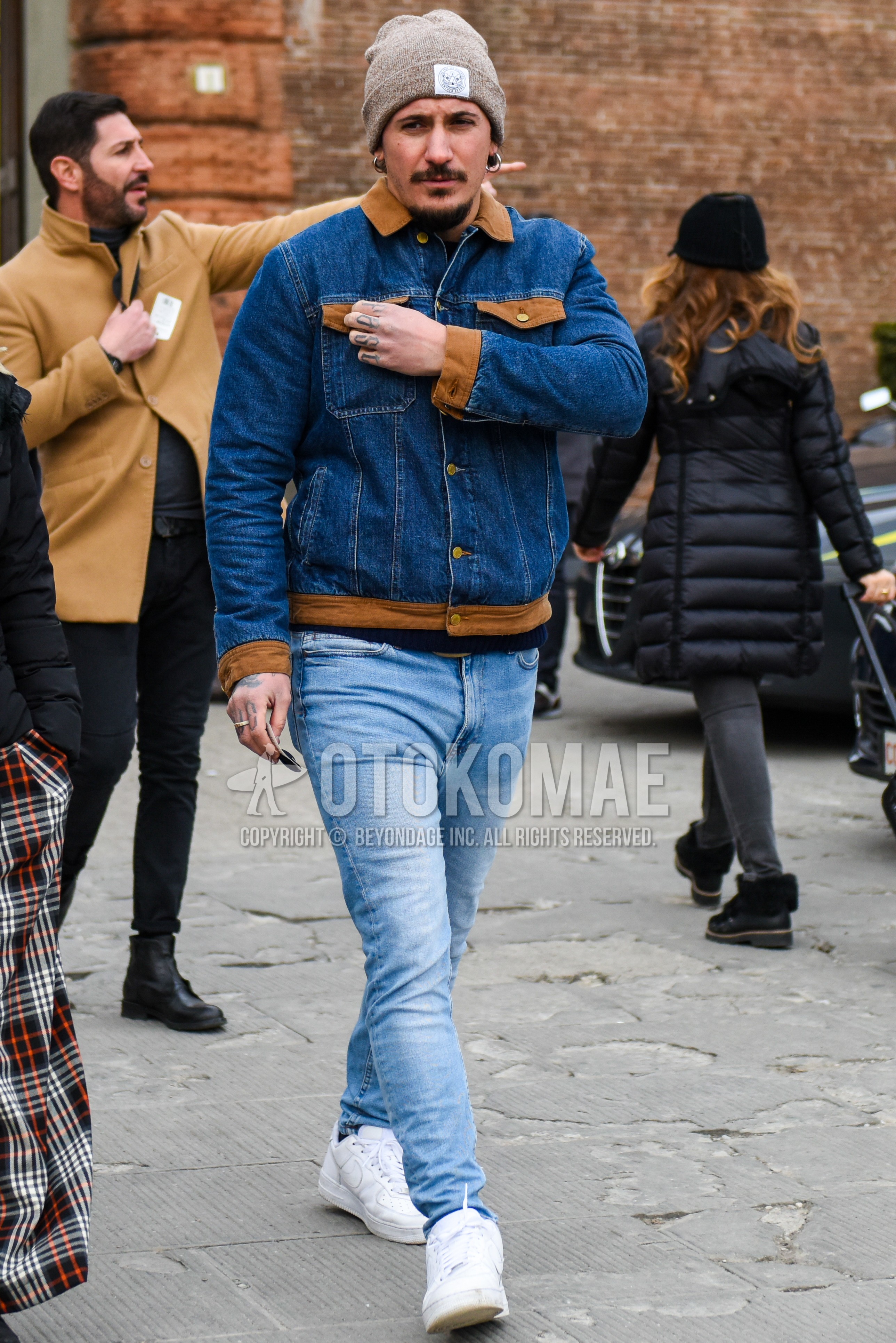 Men's winter outfit with brown plain knit cap, blue plain denim jacket, light blue plain denim/jeans, white low-cut sneakers.