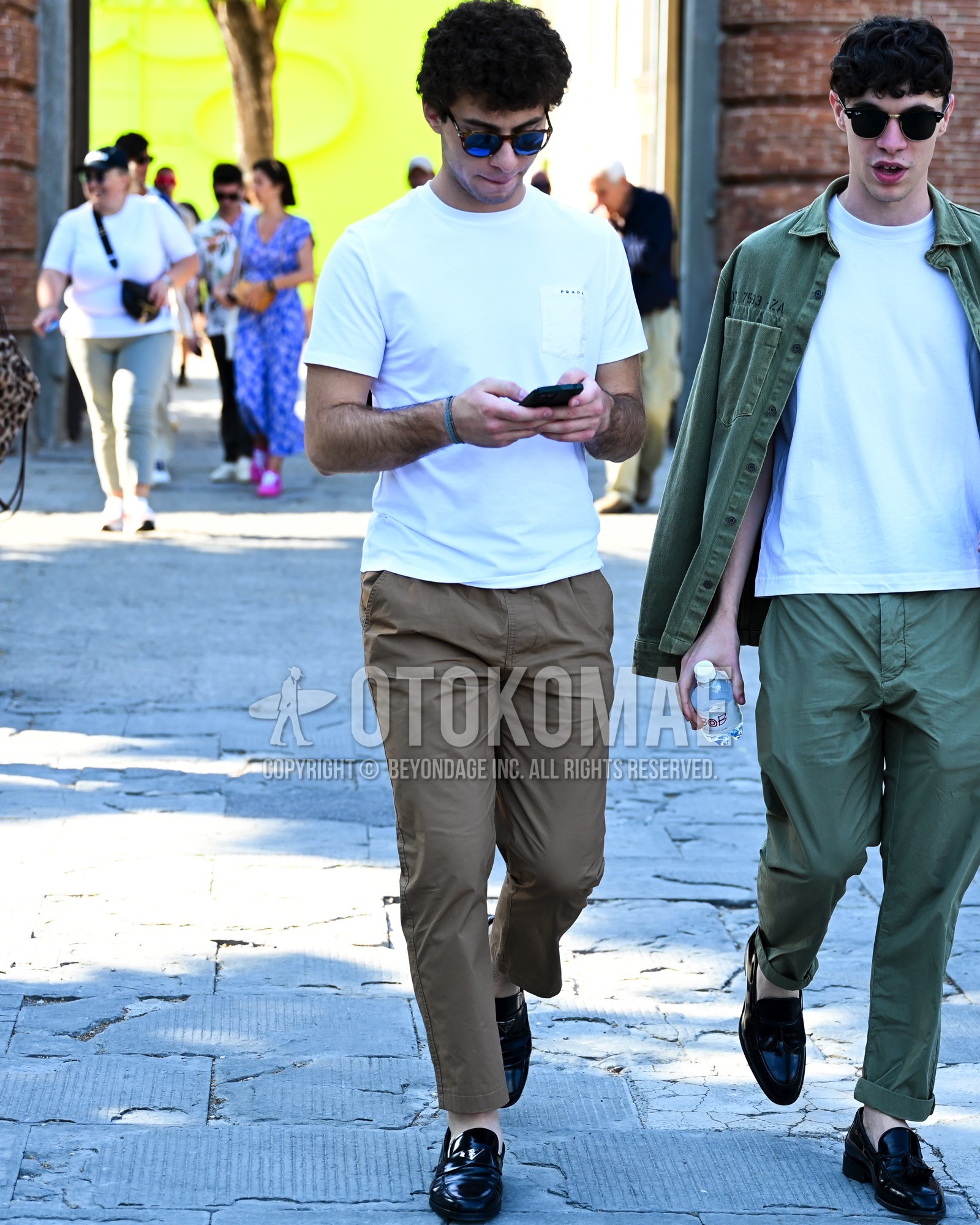 Men's spring summer outfit with black plain sunglasses, white plain t-shirt, brown plain chinos, black coin loafers leather shoes.