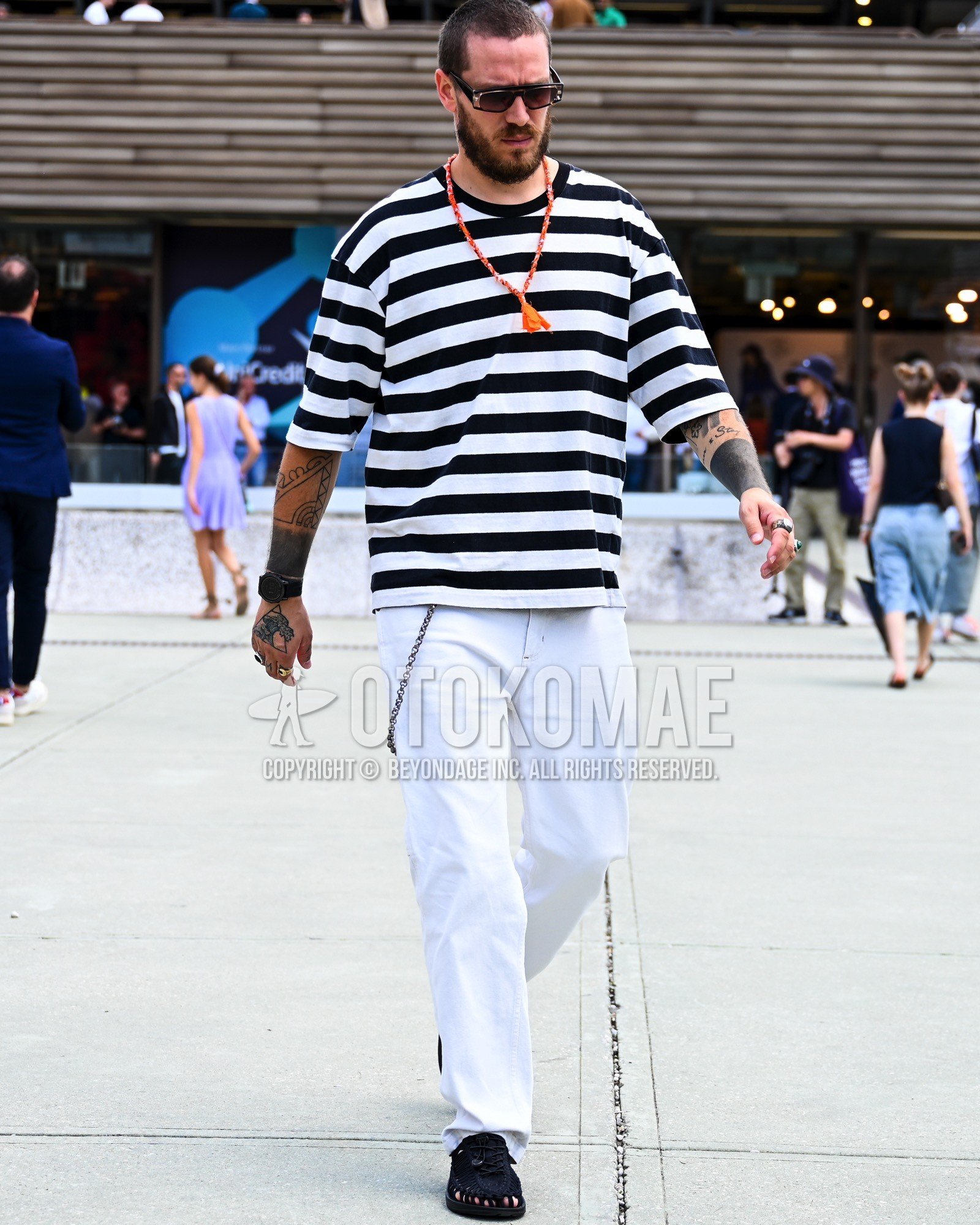 Men's spring summer outfit with white black horizontal stripes t-shirt, white plain denim/jeans, black leather sandals.