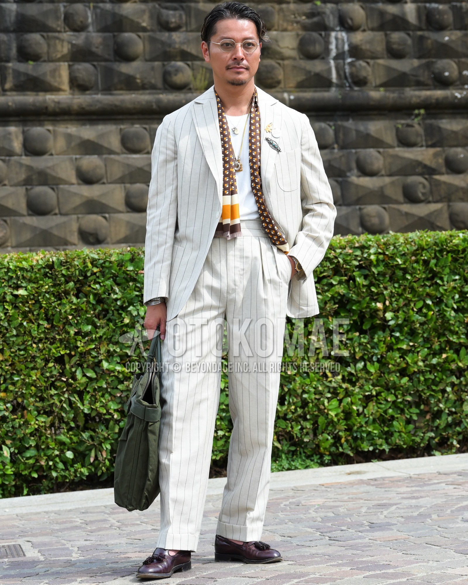 Men's spring summer autumn outfit with clear plain sunglasses, brown whole pattern scarf, white plain t-shirt, brown tassel loafers leather shoes, olive green plain briefcase/handbag, white stripes suit.