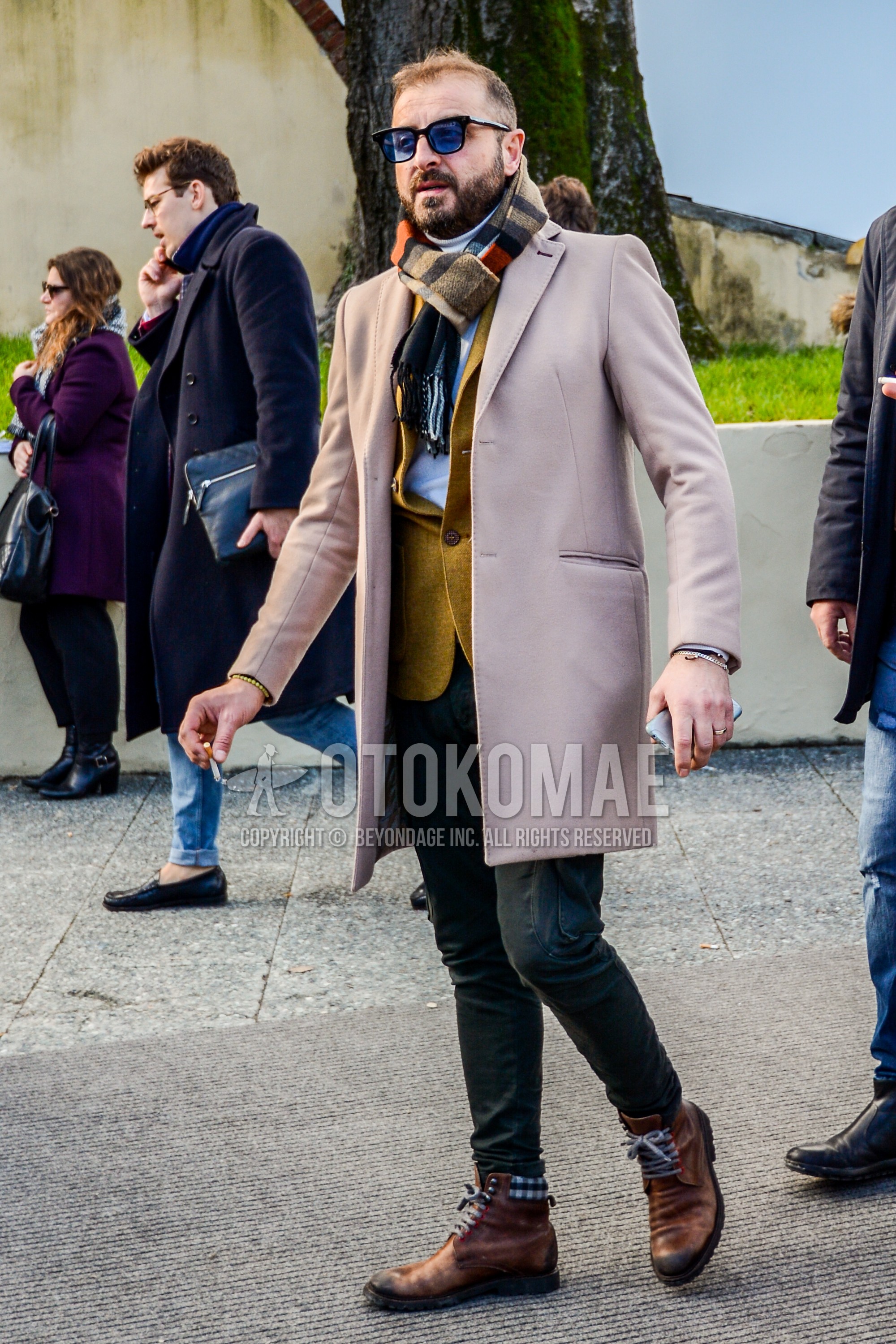 Men's autumn winter outfit with plain sunglasses, multi-color scarf scarf, beige plain chester coat, beige plain tailored jacket, white plain turtleneck knit, black plain cargo pants, brown  boots.