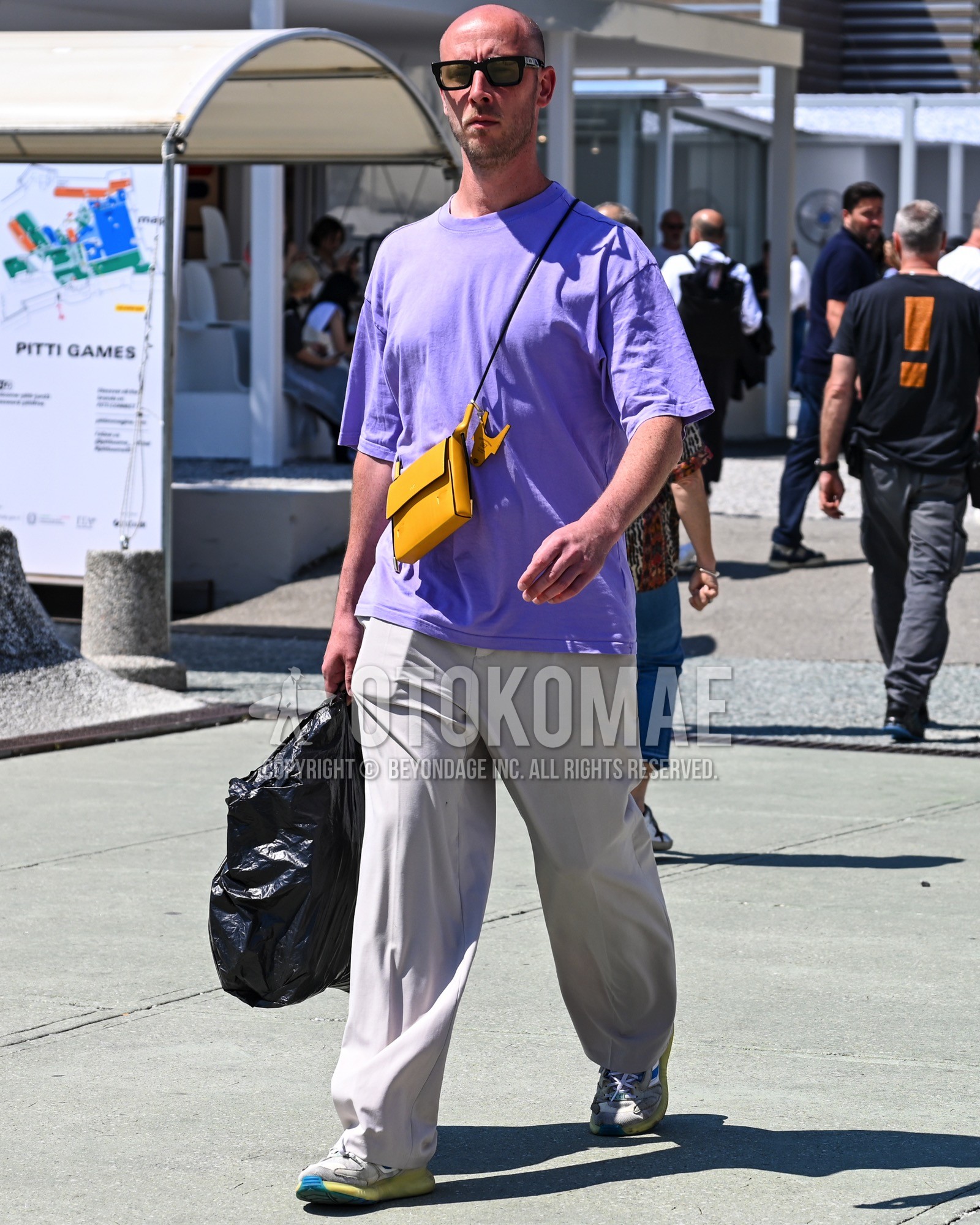 Men's spring summer outfit with yellow plain sunglasses, purple plain t-shirt, white plain wide pants, white low-cut sneakers.