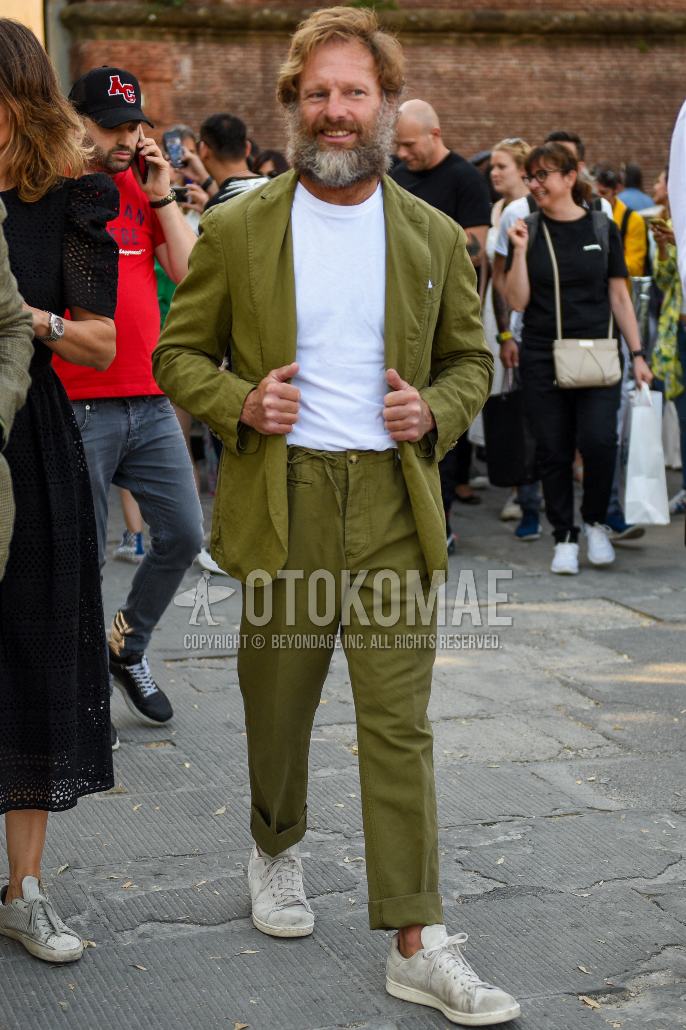 Men's spring summer outfit with white plain t-shirt, white low-cut sneakers, olive green plain suit.