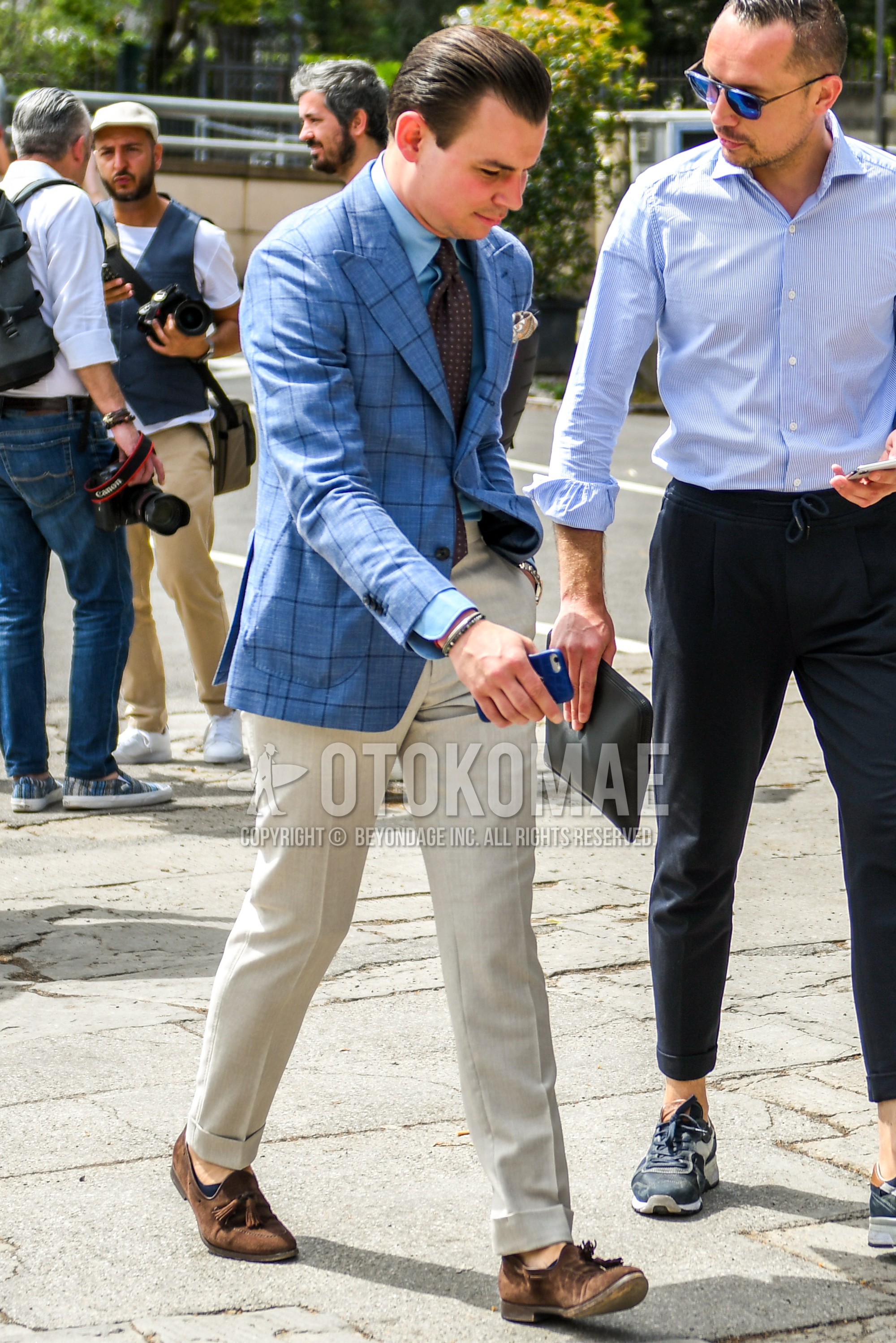 Men's spring summer autumn outfit with blue check tailored jacket, blue plain shirt, beige plain slacks, brown tassel loafers leather shoes, brown suede shoes leather shoes, brown dots necktie.