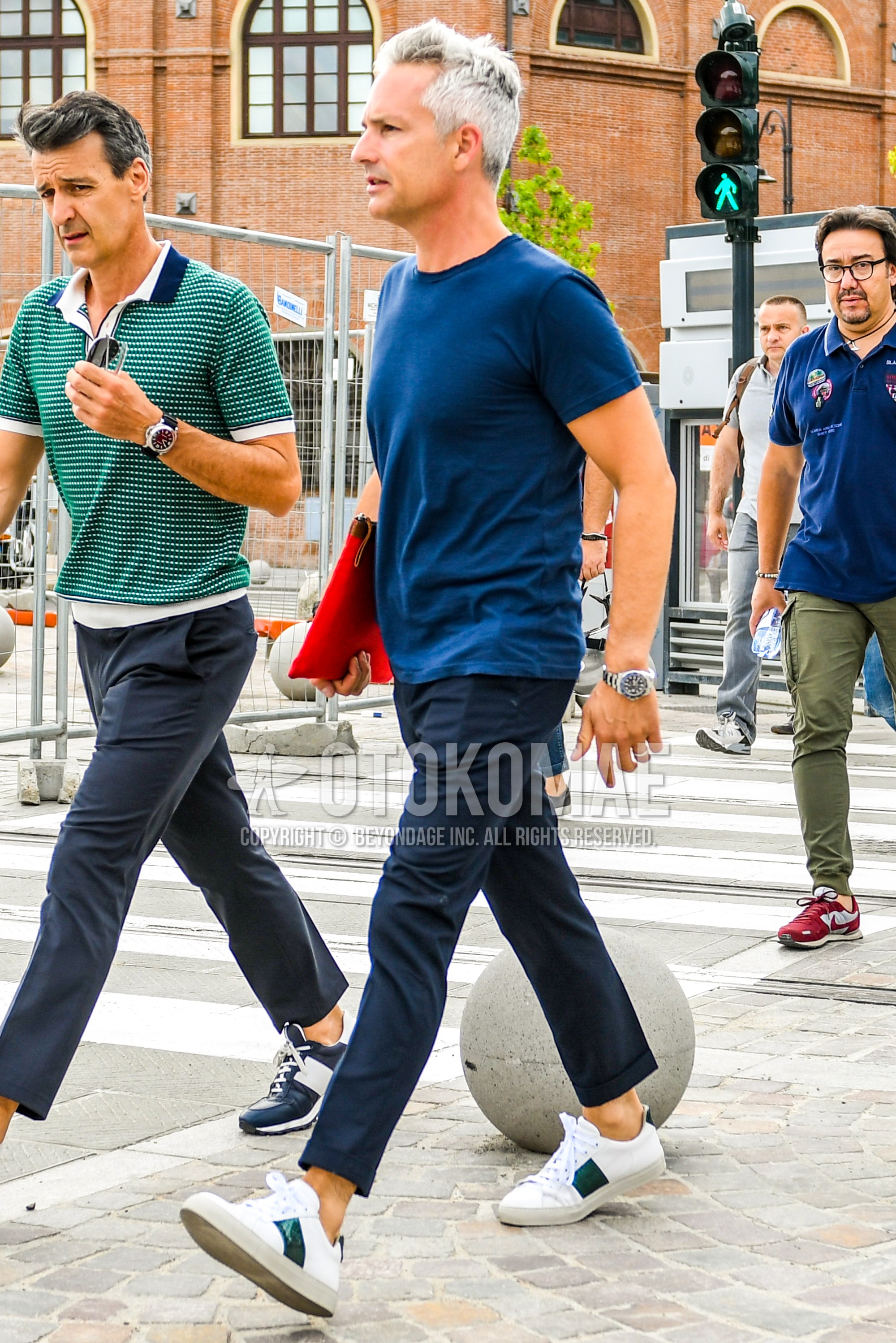Men's summer outfit with navy plain t-shirt, navy plain slacks, navy plain ankle pants, white low-cut sneakers, red plain clutch bag/second bag/drawstring bag.