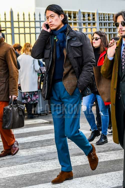 ネイビー無地のマフラー/ストール、ブラウン無地のM-65、ブラウンチェックのテーラードジャケット、ネイビー無地のセーター、グレー無地のスラックス、ブラウンモンクシューズの革靴、スエードシューズの革靴を合わせた秋冬のメンズコーデ・着こなし。