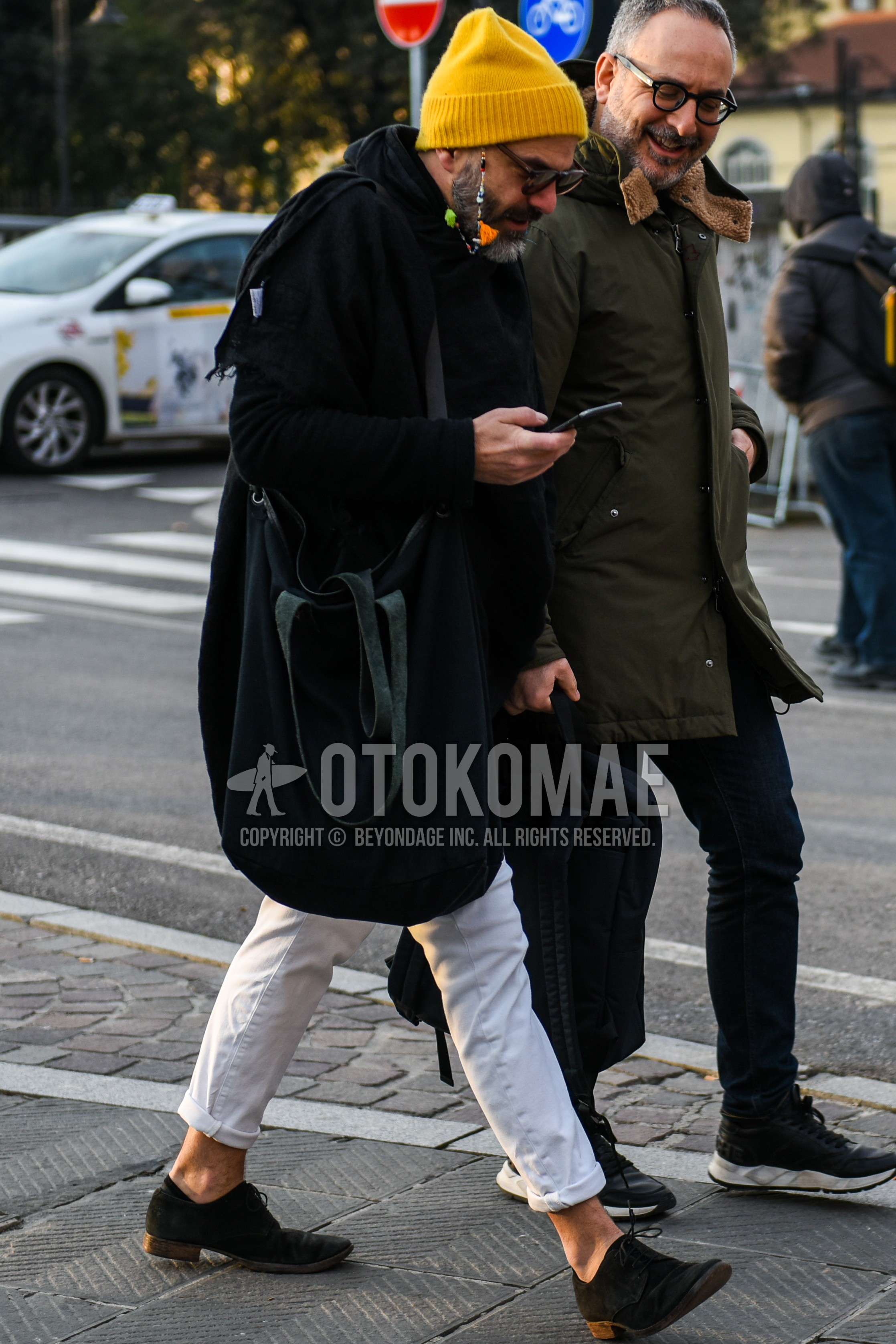 Men's autumn winter outfit with yellow plain knit cap, black plain sunglasses, black plain hooded coat, white plain cotton pants, black plain toe leather shoes, black plain shoulder bag.