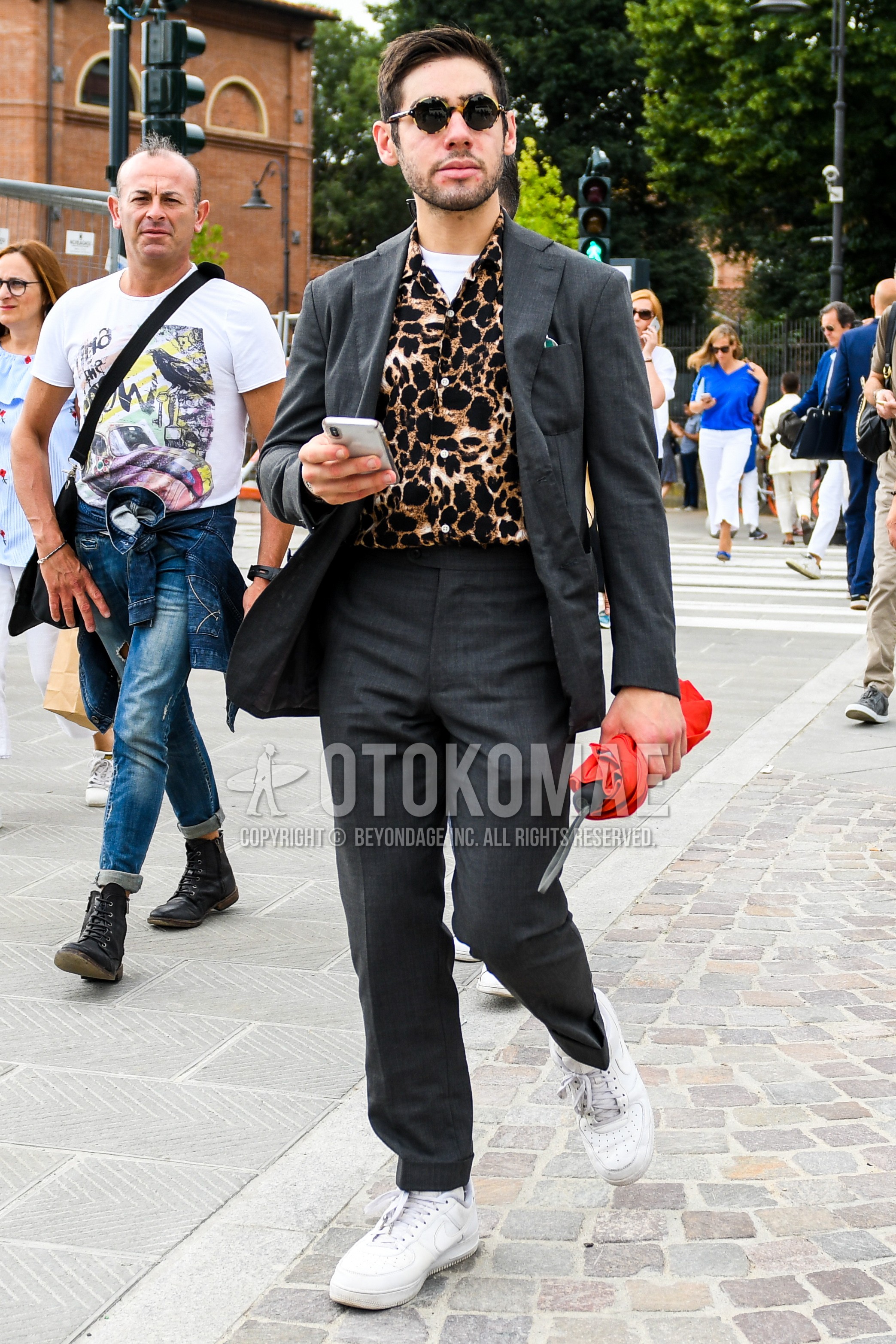 Men's spring summer autumn outfit with tortoiseshell sunglasses, multi-color leopard shirt, white low-cut sneakers, gray plain suit.