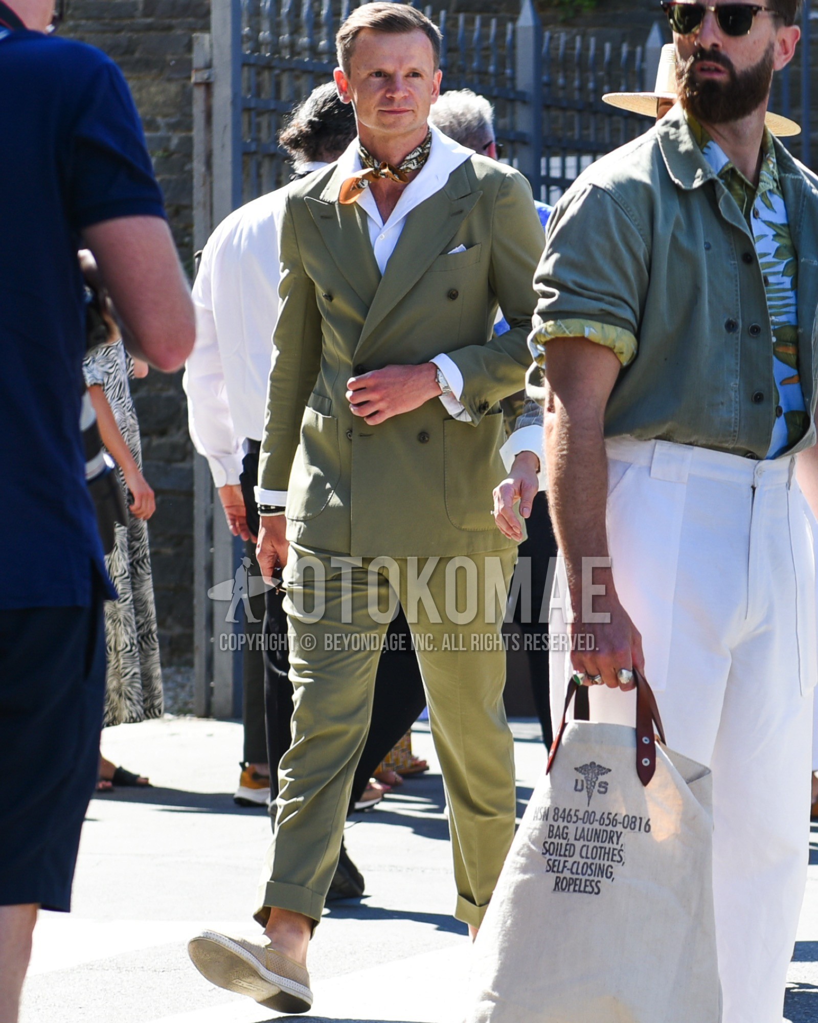 Men's spring summer outfit with brown scarf bandana/neckerchief, white plain shirt, beige slip-on sneakers, green plain suit.