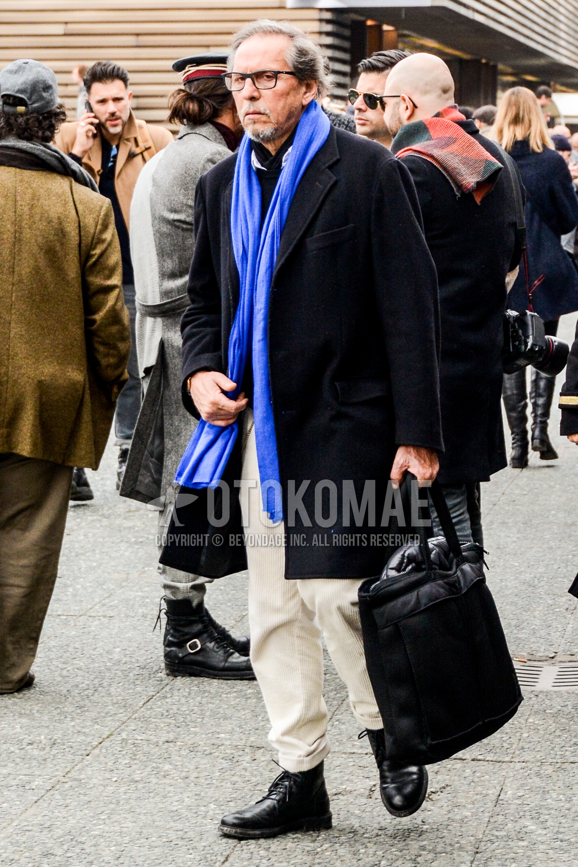 Men's autumn winter outfit with plain glasses, blue plain scarf, black plain chester coat, white plain winter pants (corduroy,velour), black chukka boots, black plain briefcase/handbag.