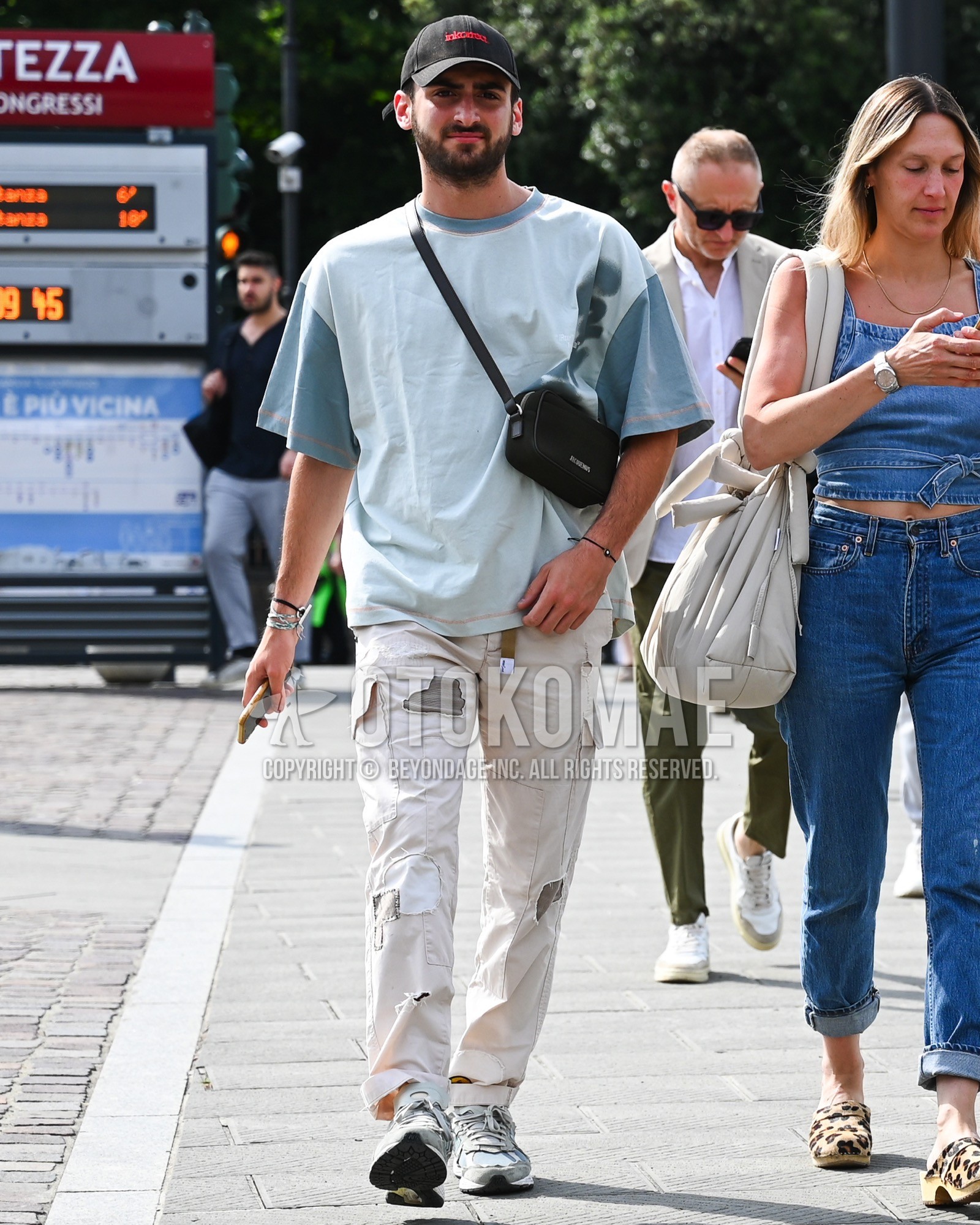 Men's spring summer outfit with black one point baseball cap, light blue plain t-shirt, white plain cargo pants, white low-cut sneakers, black one point body bag.