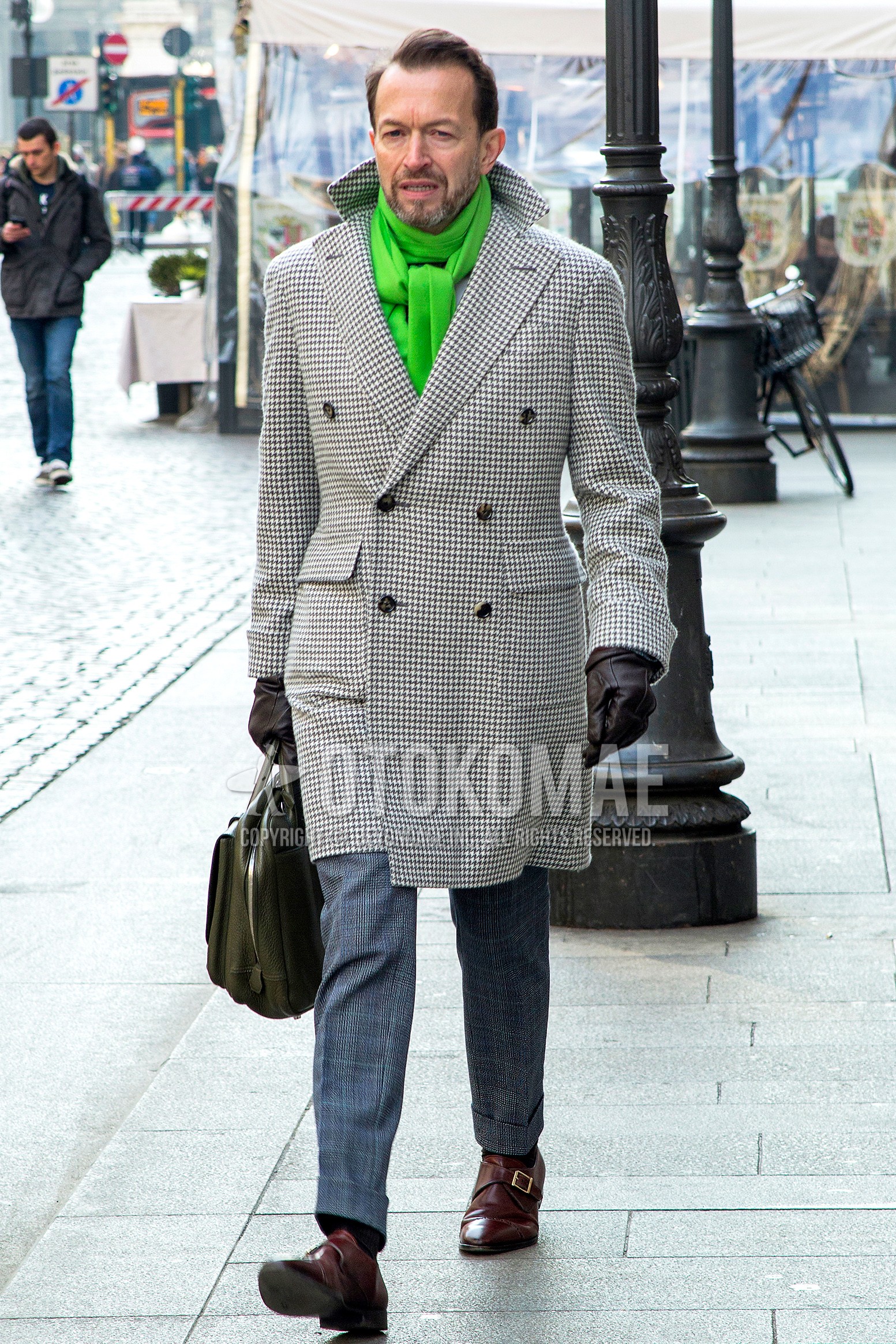 Men's winter outfit with green plain scarf, gray plain chester coat, gray check slacks, black plain socks, brown monk shoes leather shoes, olive green plain briefcase/handbag.