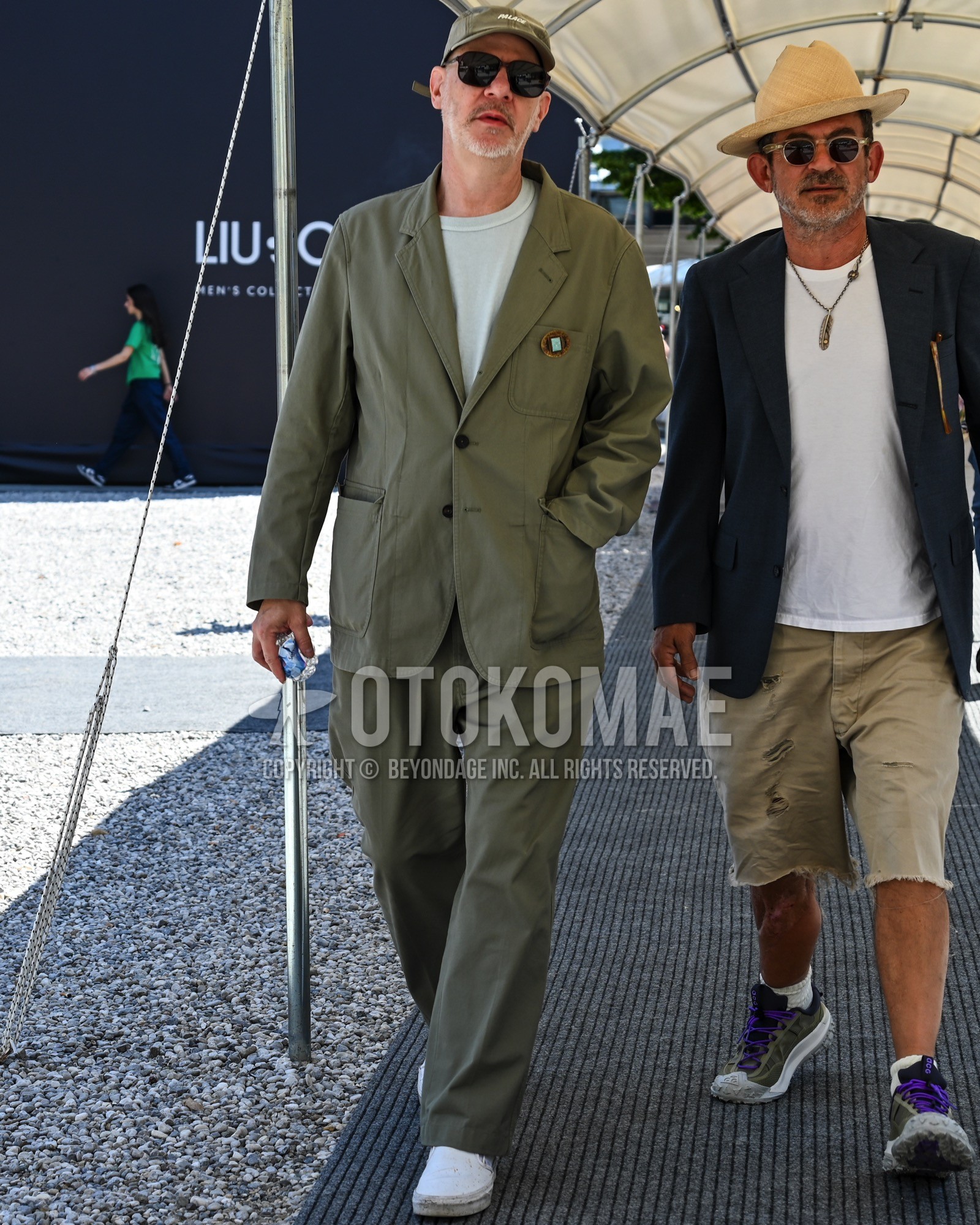 Men's spring summer autumn outfit with olive green one point baseball cap, white plain t-shirt, white low-cut sneakers, olive green plain suit.
