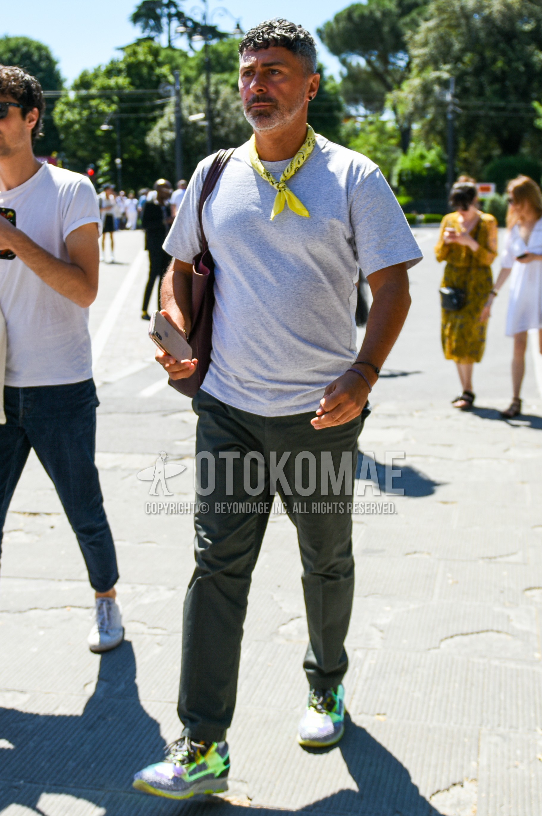 Men's summer outfit with yellow plain scarf, gray plain t-shirt, olive green plain cotton pants, yellow gray low-cut sneakers.