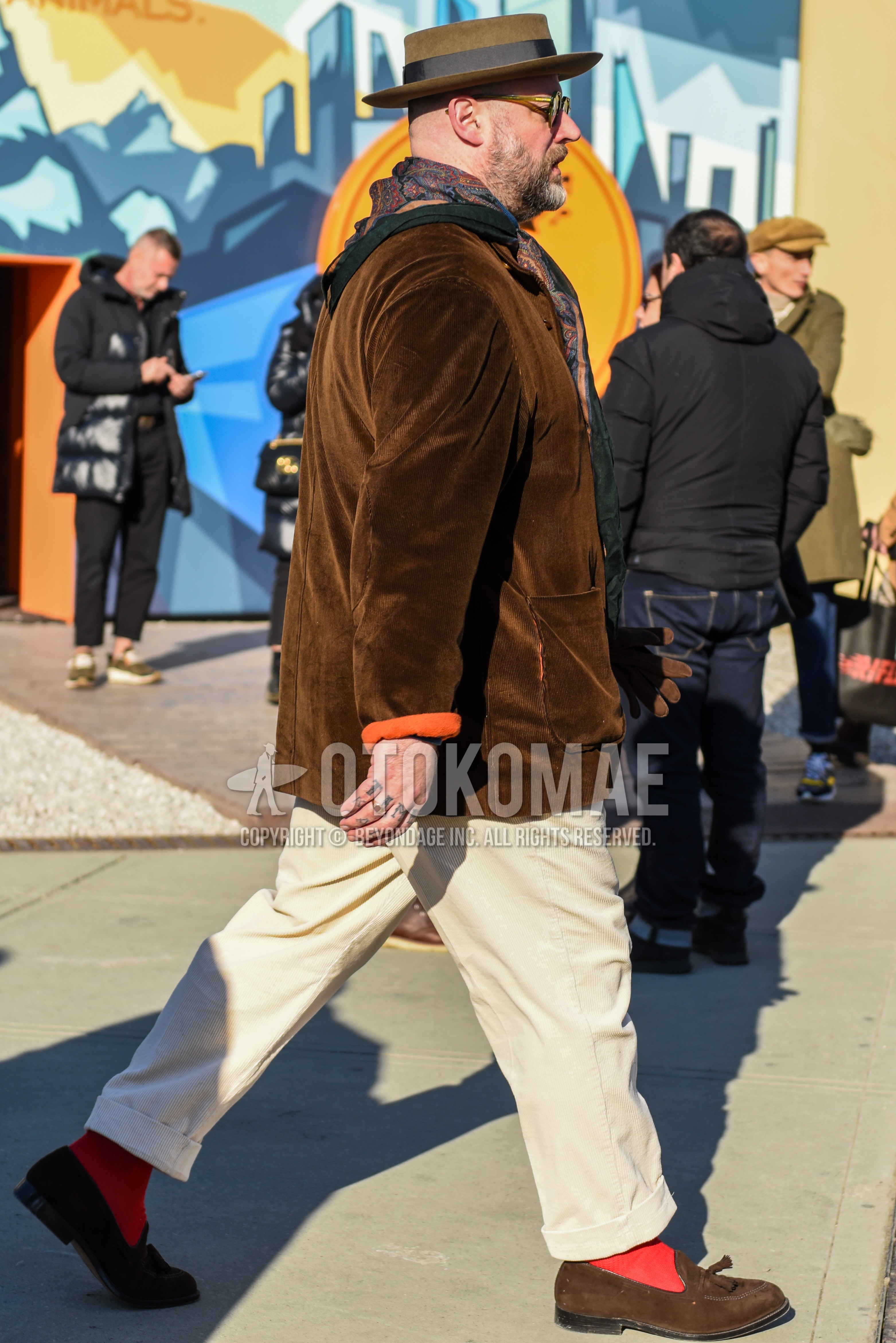 Men's autumn winter outfit with beige plain hat, olive green clear plain sunglasses, multi-color scarf scarf, brown plain outerwear, beige plain chinos, orange plain socks, brown tassel loafers leather shoes.