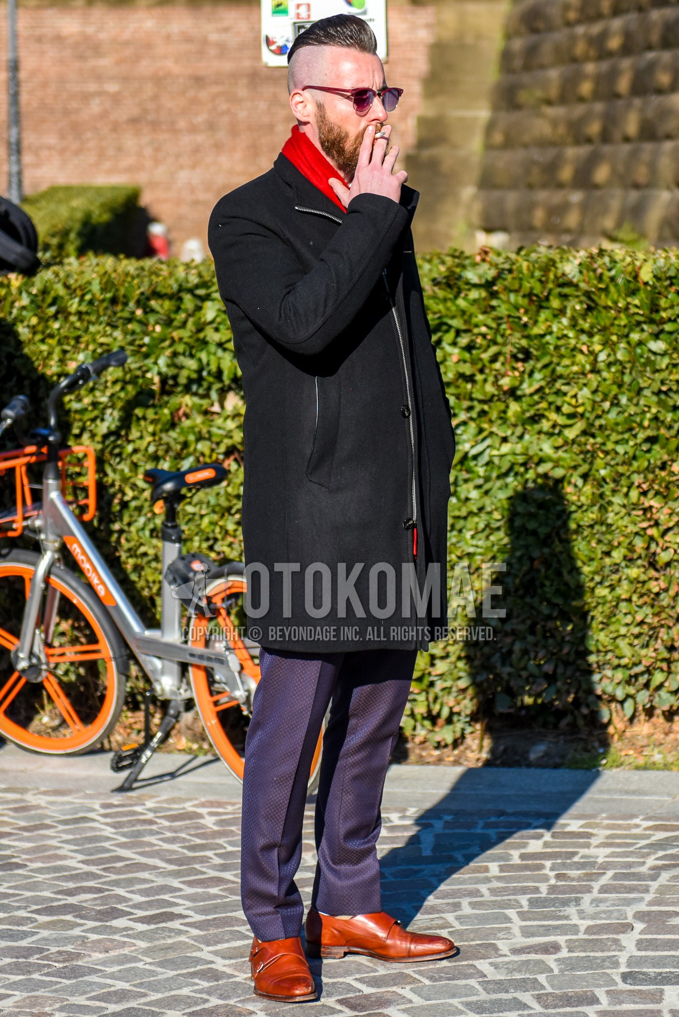 Men's winter outfit with red plain sunglasses, red plain scarf, black plain outerwear, navy bottoms slacks, brown monk shoes leather shoes.