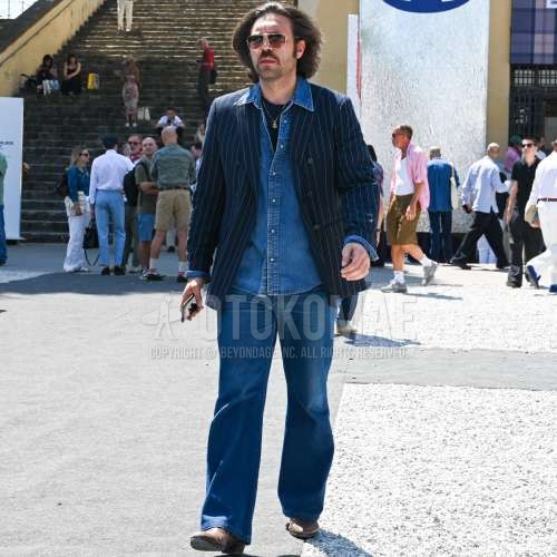 ゴールド無地のサングラス、ネイビーストライプのテーラードジャケット、ブルー無地のデニム/シャンブレーシャツ、ネイビー無地のTシャツ、ブルー無地のデニム/ジーンズ、ブラウンのブーツを合わせた夏春のメンズコーデ・着こなし。