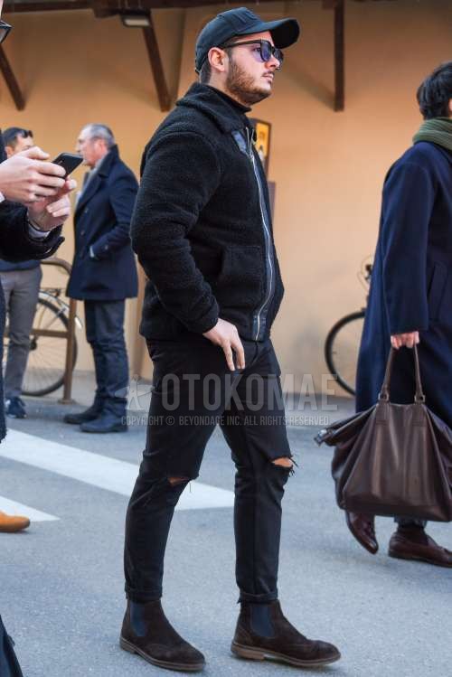 黒無地のベースボールキャップ、黒無地のサングラス、黒無地のフリースジャケット、黒無地のタートルネックニット、黒無地のダメージジーンズ、スエード のブラウンサイドゴアのブーツを合わせた秋冬のメンズコーデ・着こなし。