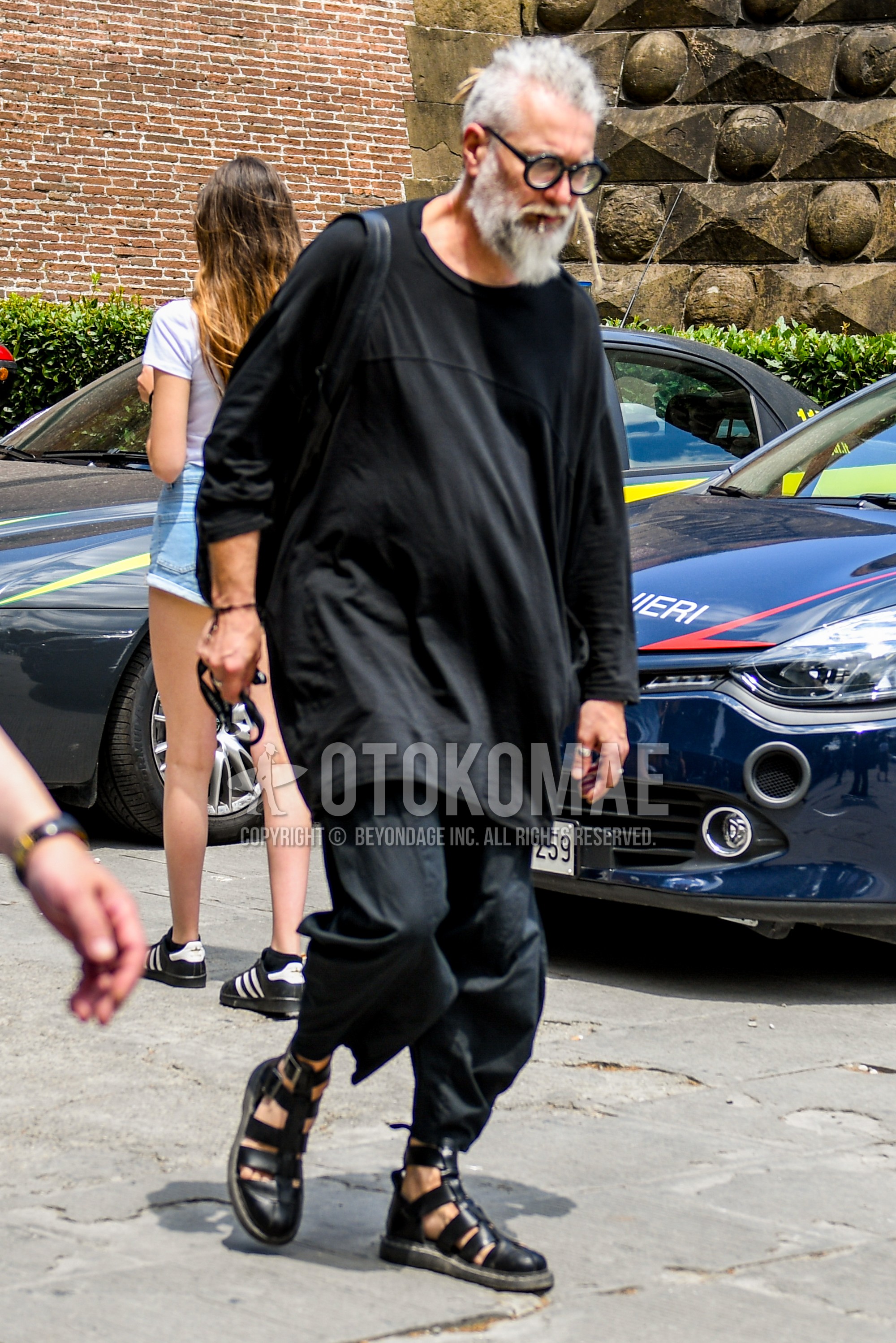 Men's summer outfit with plain sunglasses, black plain t-shirt, black plain cropped pants, black gurkha sandals.
