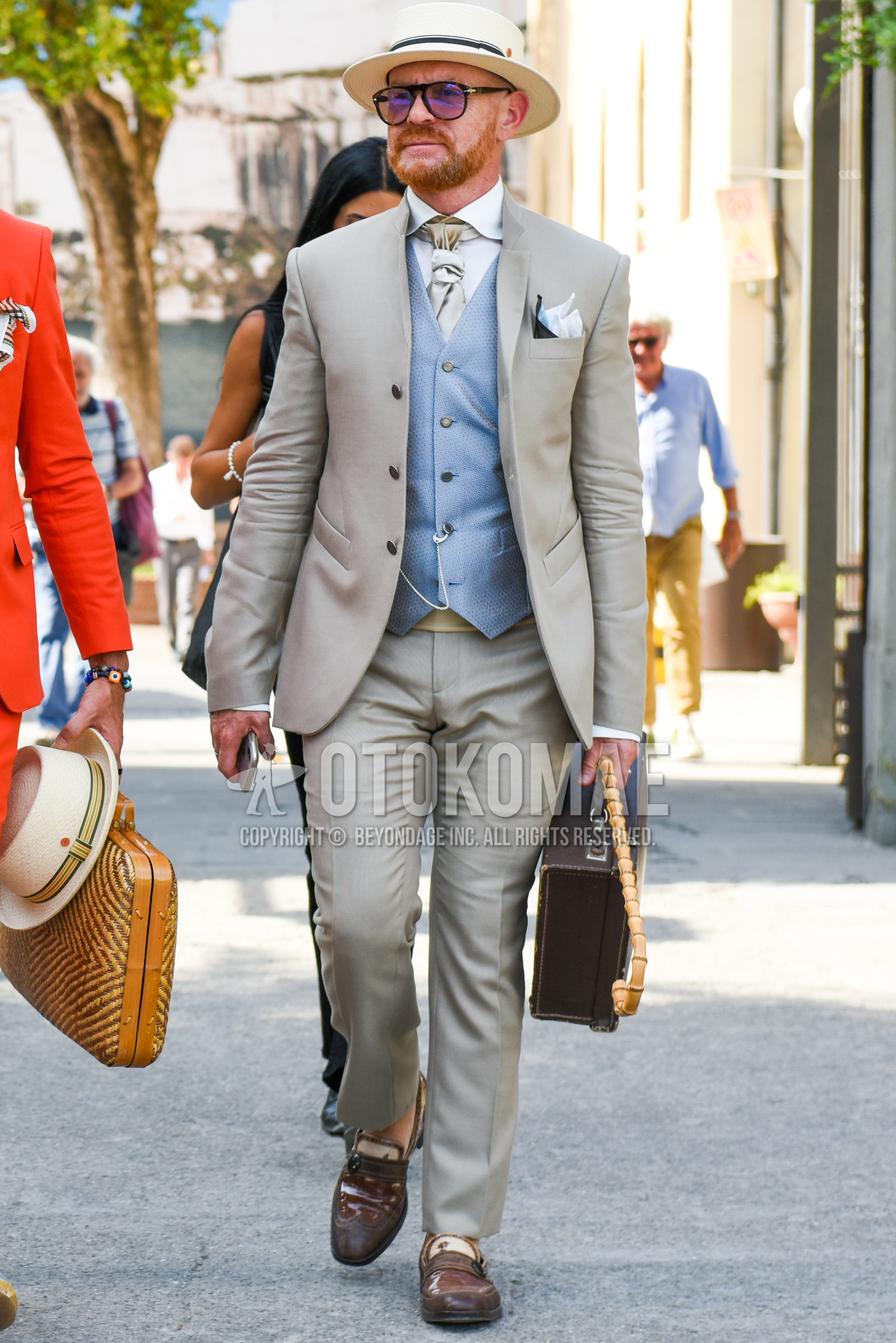 Men's spring autumn outfit with beige plain hat, brown tortoiseshell sunglasses, white plain shirt, gray plain gilet, brown  leather shoes, brown plain attache case, gray plain suit, beige plain necktie.