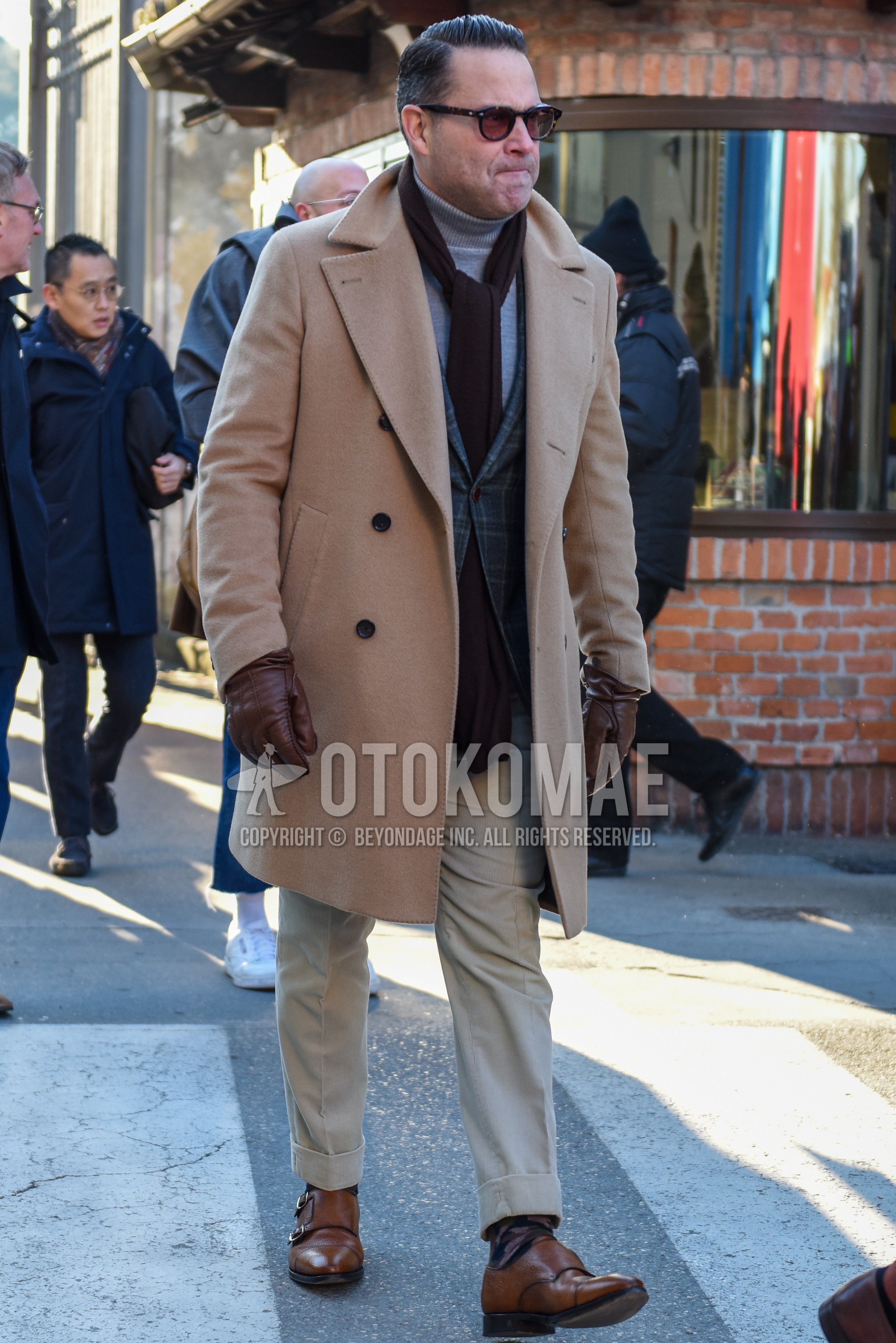 Men's autumn winter outfit with brown tortoiseshell sunglasses, brown plain scarf, beige plain chester coat, gray check tailored jacket, gray plain turtleneck knit, beige plain chinos, multi-color socks socks, brown monk shoes leather shoes.