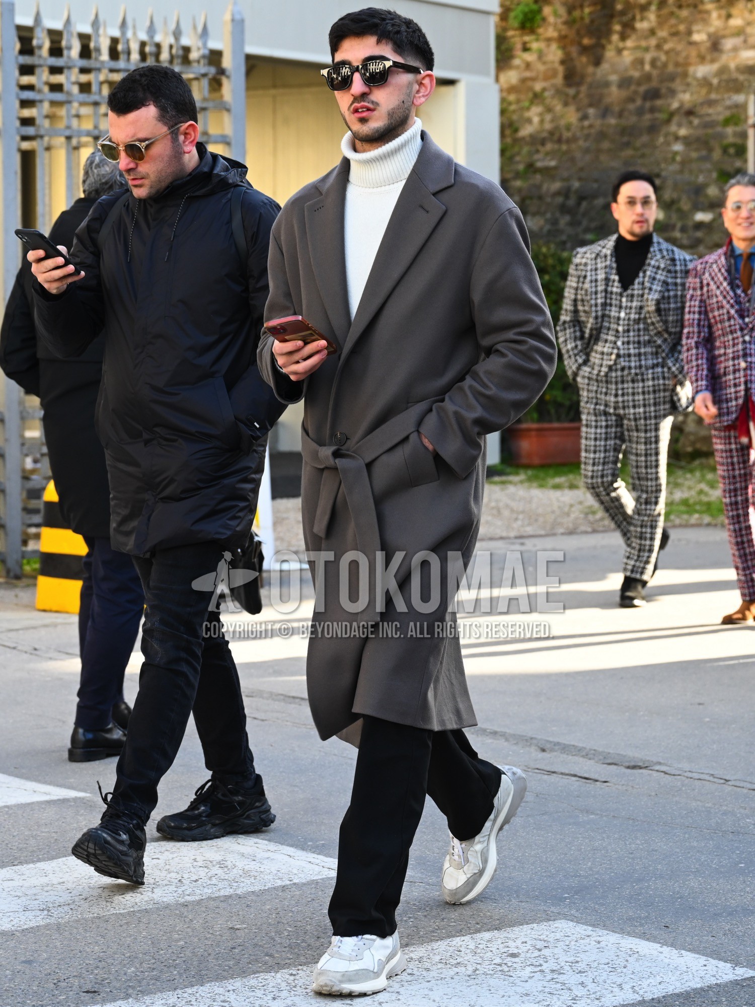 Men's autumn winter outfit with plain sunglasses, gray plain belted coat, white plain turtleneck knit, black plain slacks, gray low-cut sneakers.
