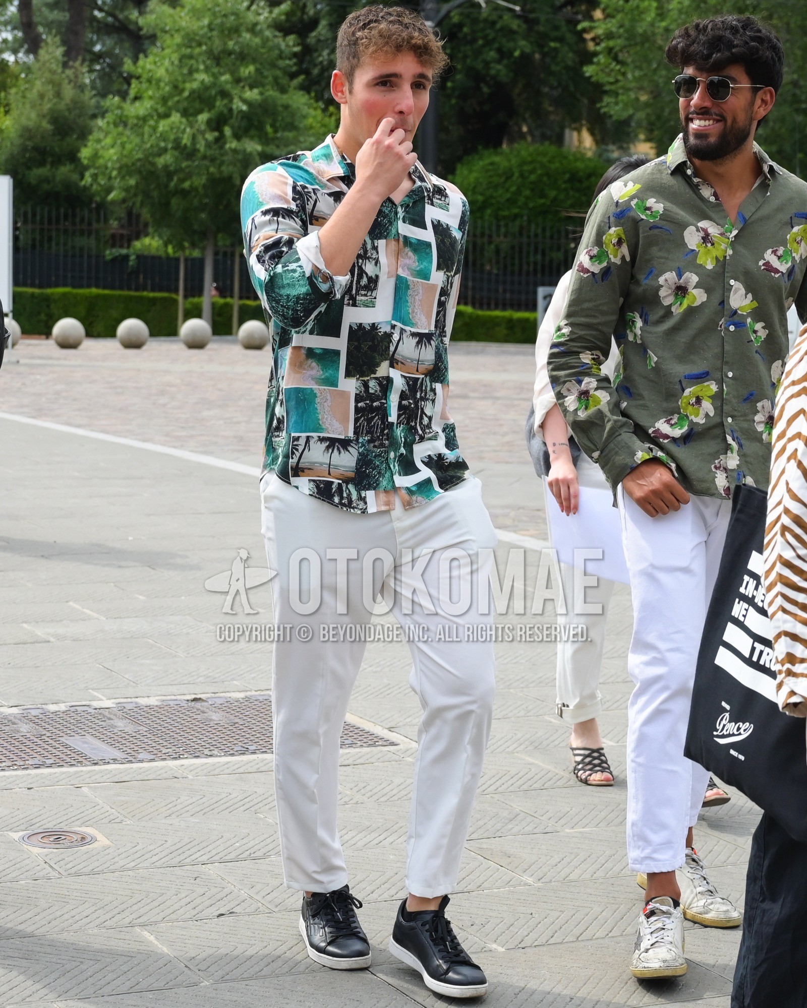 Men's spring summer autumn outfit with green whole pattern shirt, white plain slacks, black low-cut sneakers.