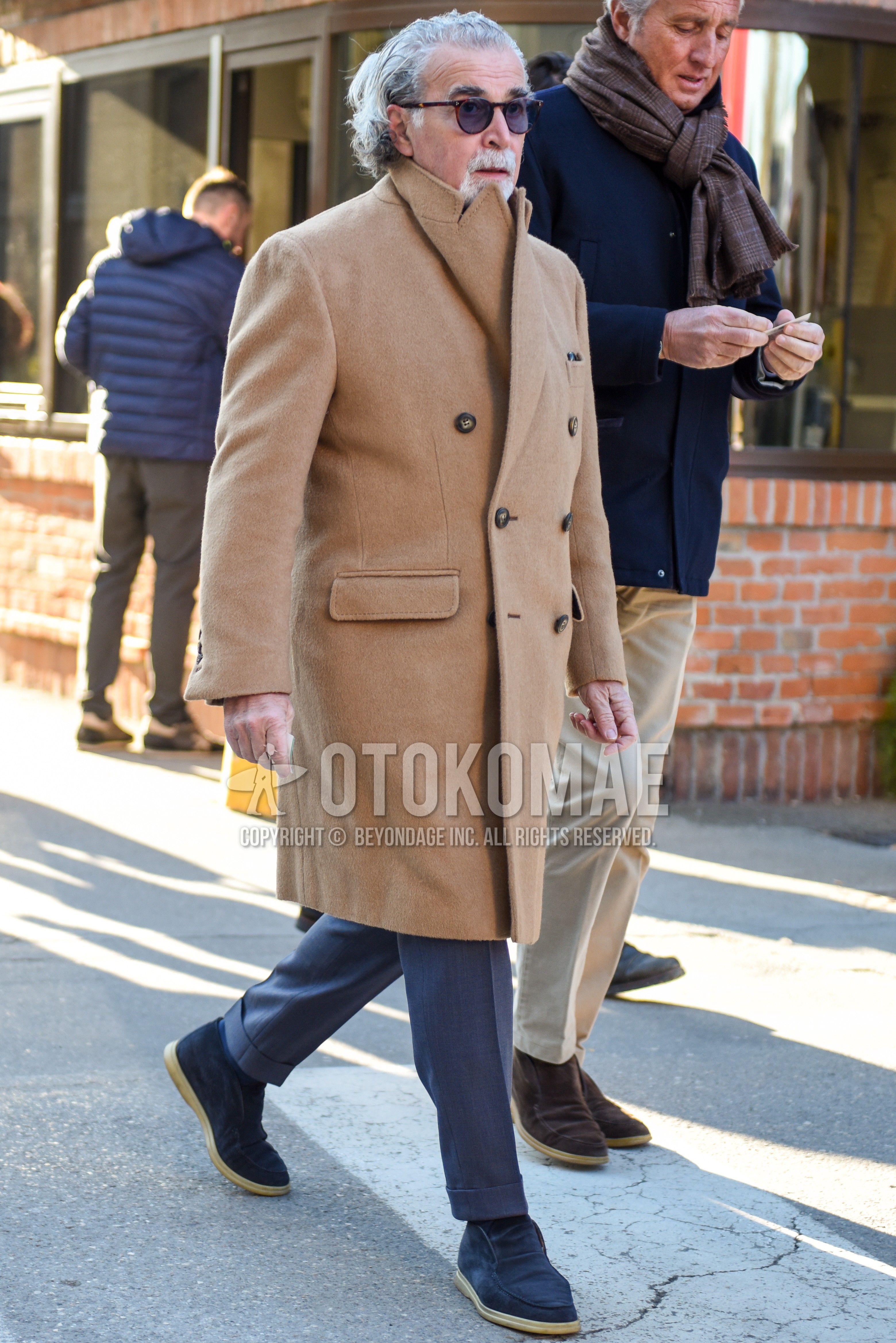 Men's autumn winter outfit with brown tortoiseshell sunglasses, beige plain chester coat, gray plain ankle pants, gray plain slacks, navy plain socks, navy high-cut sneakers.