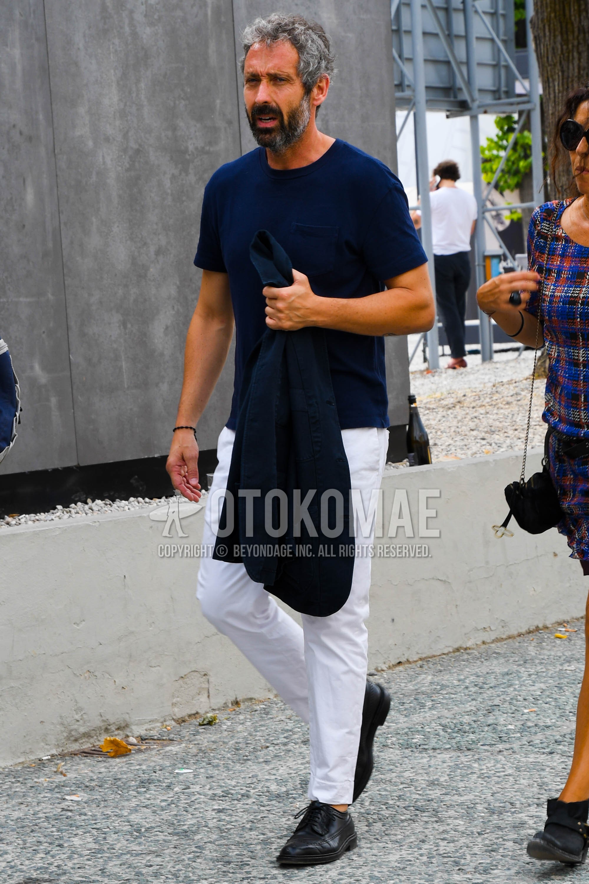 Men's spring summer outfit with navy plain t-shirt, white plain cotton pants, black wing-tip shoes leather shoes.