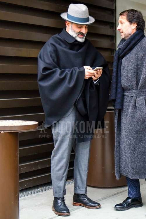 グレー無地のハット、ダークグレー無地のアウター、黒カントリーのブーツ、グレー無地のスーツを合わせた秋冬のメンズコーデ・着こなし。
