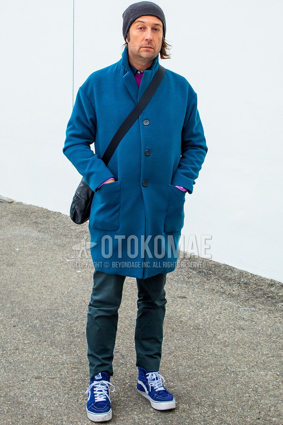 Men's winter outfit with dark gray plain knit cap, blue plain chester coat, purple plain sweater, green plain chinos, blue high-cut sneakers.