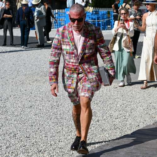 ブラウンべっ甲のサングラス、マルチカラーアウターのテーラードジャケット、ピンク無地のTシャツ、マルチカラーボトムスのショートパンツ、黒プレーントゥの革靴、マルチカラースーツのカジュアルセットアップを合わせた夏春のメンズコーデ・着こなし。