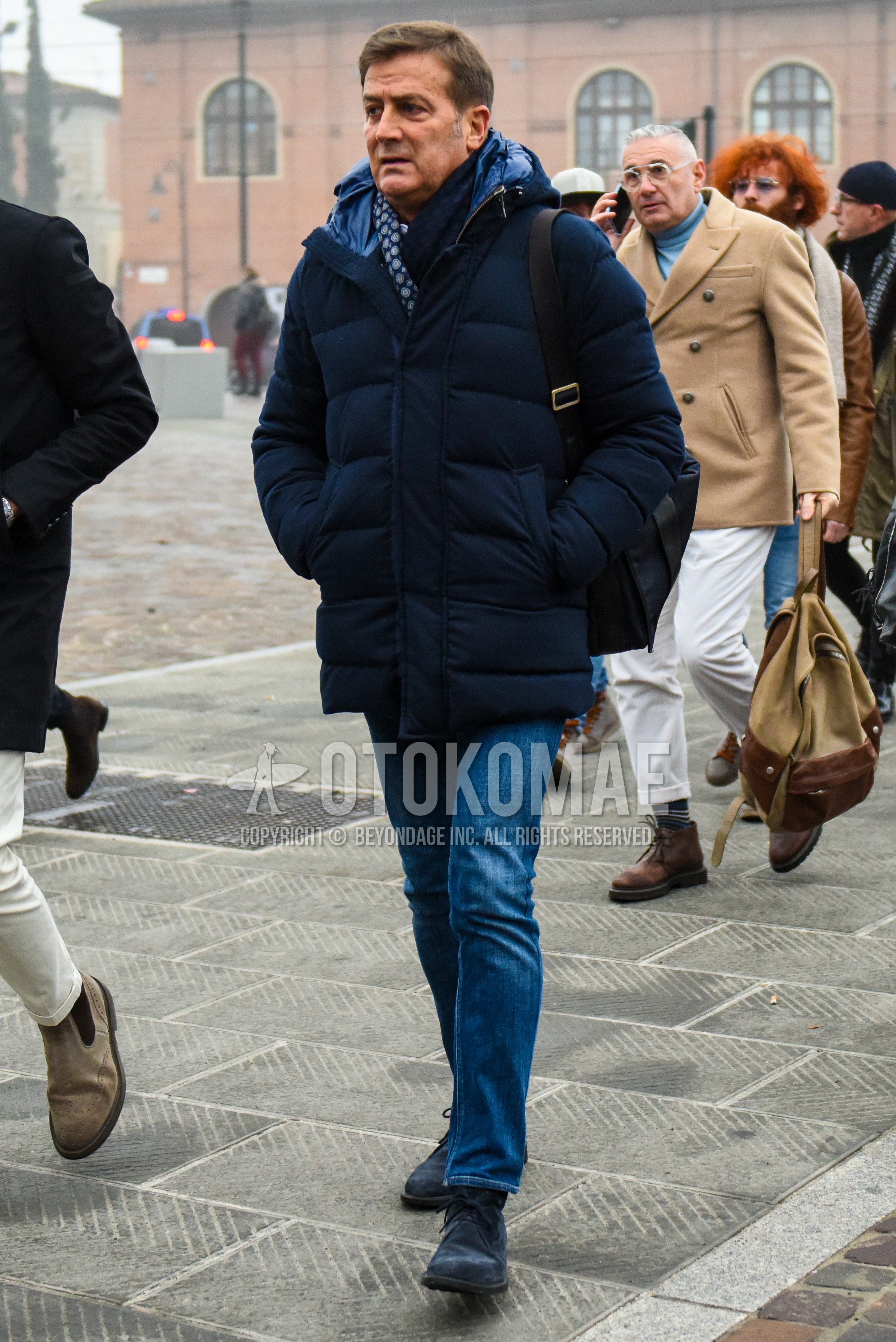 Men's winter outfit with navy plain down jacket, blue plain denim/jeans, navy chukka boots.