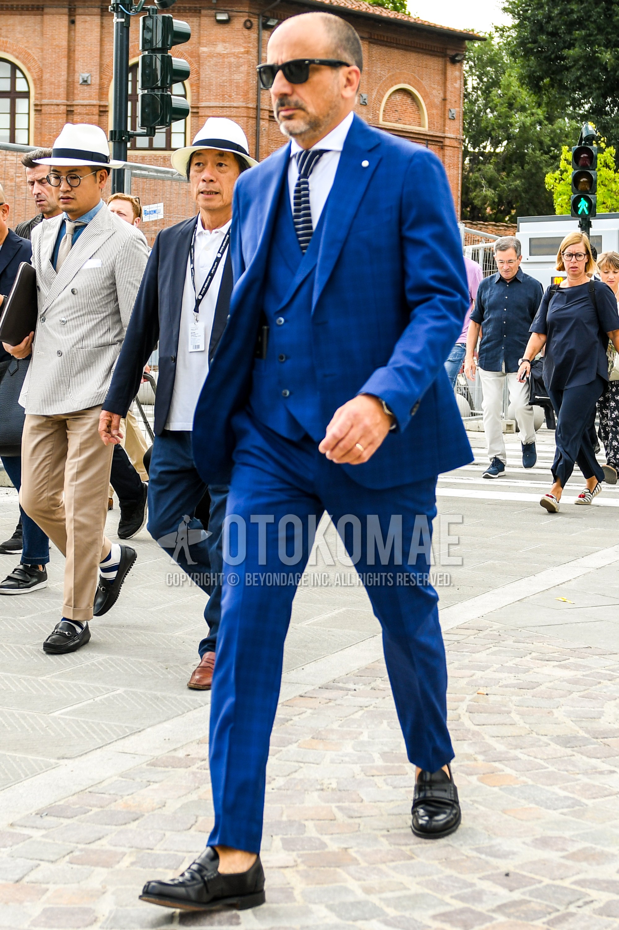 Men's spring summer autumn outfit with plain sunglasses, white plain shirt, black coin loafers leather shoes, blue plain three-piece suit, black necktie necktie.
