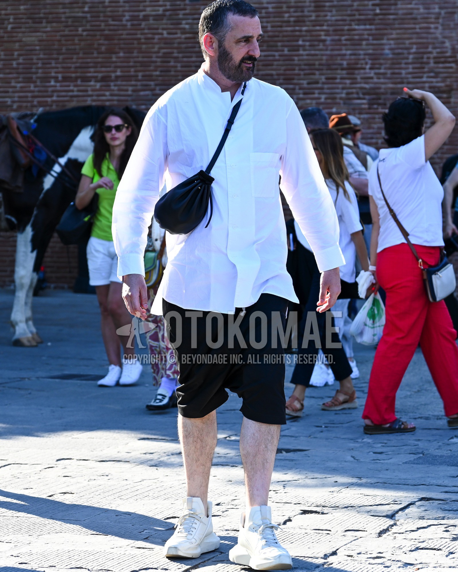 Men's spring summer outfit with white plain shirt, black plain short pants, white high-cut sneakers, black plain body bag.