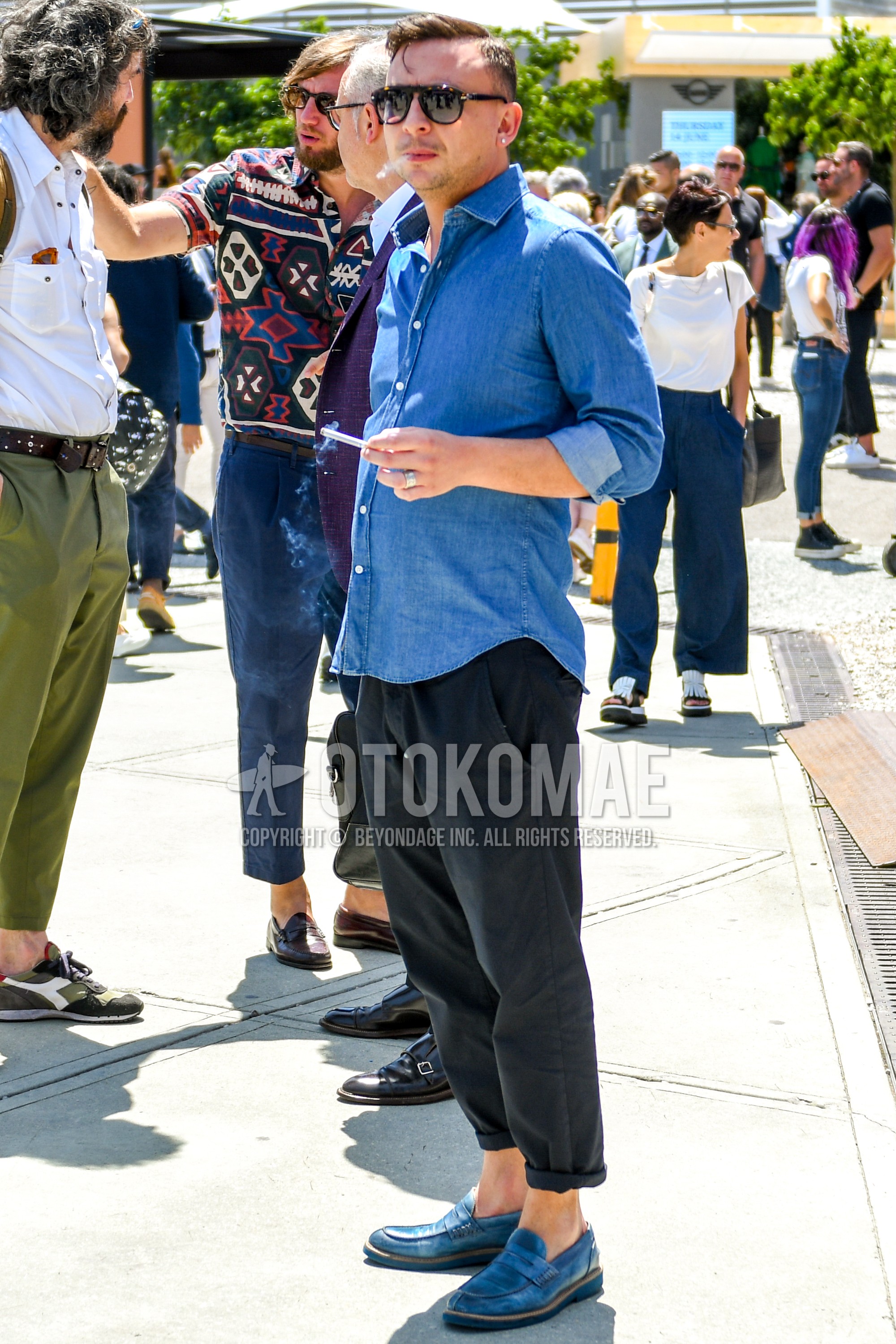 Men's summer outfit with tortoiseshell sunglasses, blue plain denim shirt/chambray shirt, black plain cropped pants, blue coin loafers leather shoes.