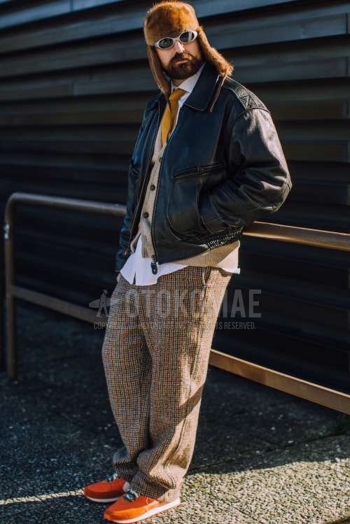 ブラウン無地のキャップ、シルバー無地のサングラス、黒無地のレザージャケット(ライダース以外)、黒無地のミリタリージャケット(MA-1、M-65以外)、ベージュ無地のカーディガン、白無地のシャツ、ブラウンチェックの冬パンツ(コーデュロイ,ベロア)、ブラウンチェックのスラックス、ナイキのオレンジスニーカー、イエロー無地のネクタイを合わせた冬春のメンズコーデ・着こなし。