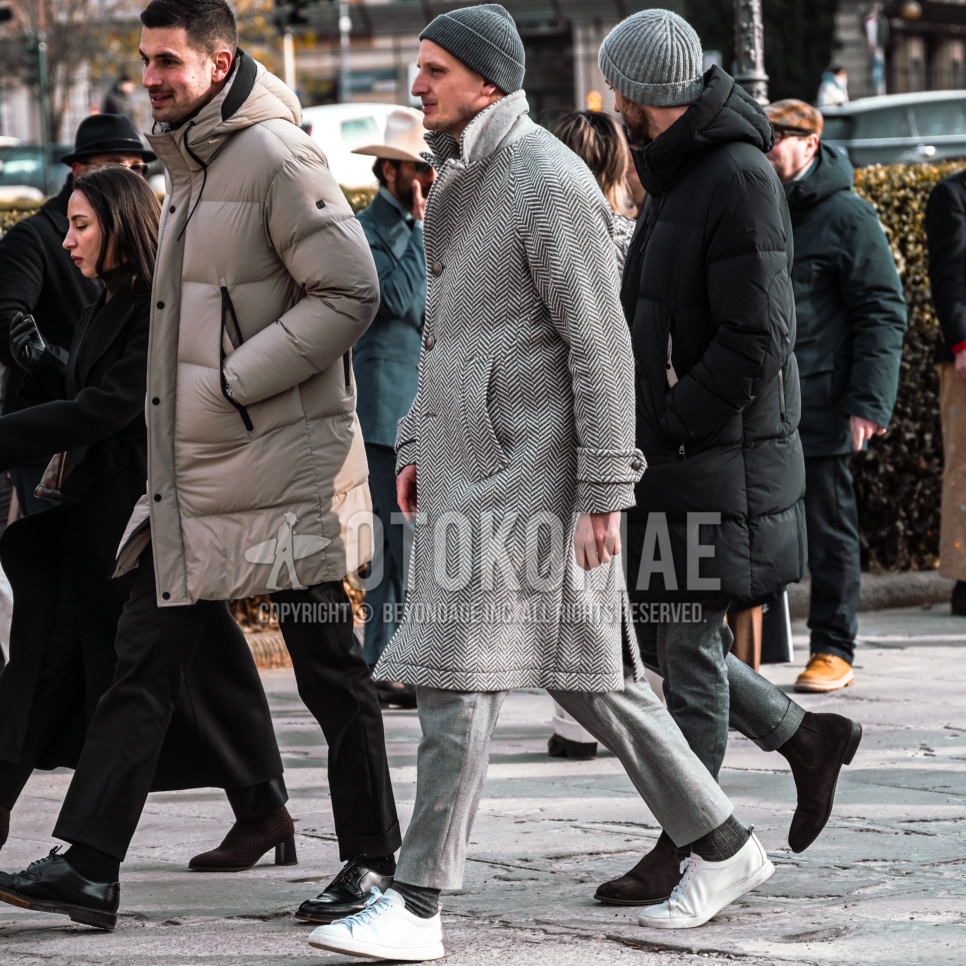Men's autumn winter outfit with dark gray plain knit cap, gray herringbone chester coat, gray plain ankle pants, dark gray plain socks, white low-cut sneakers.